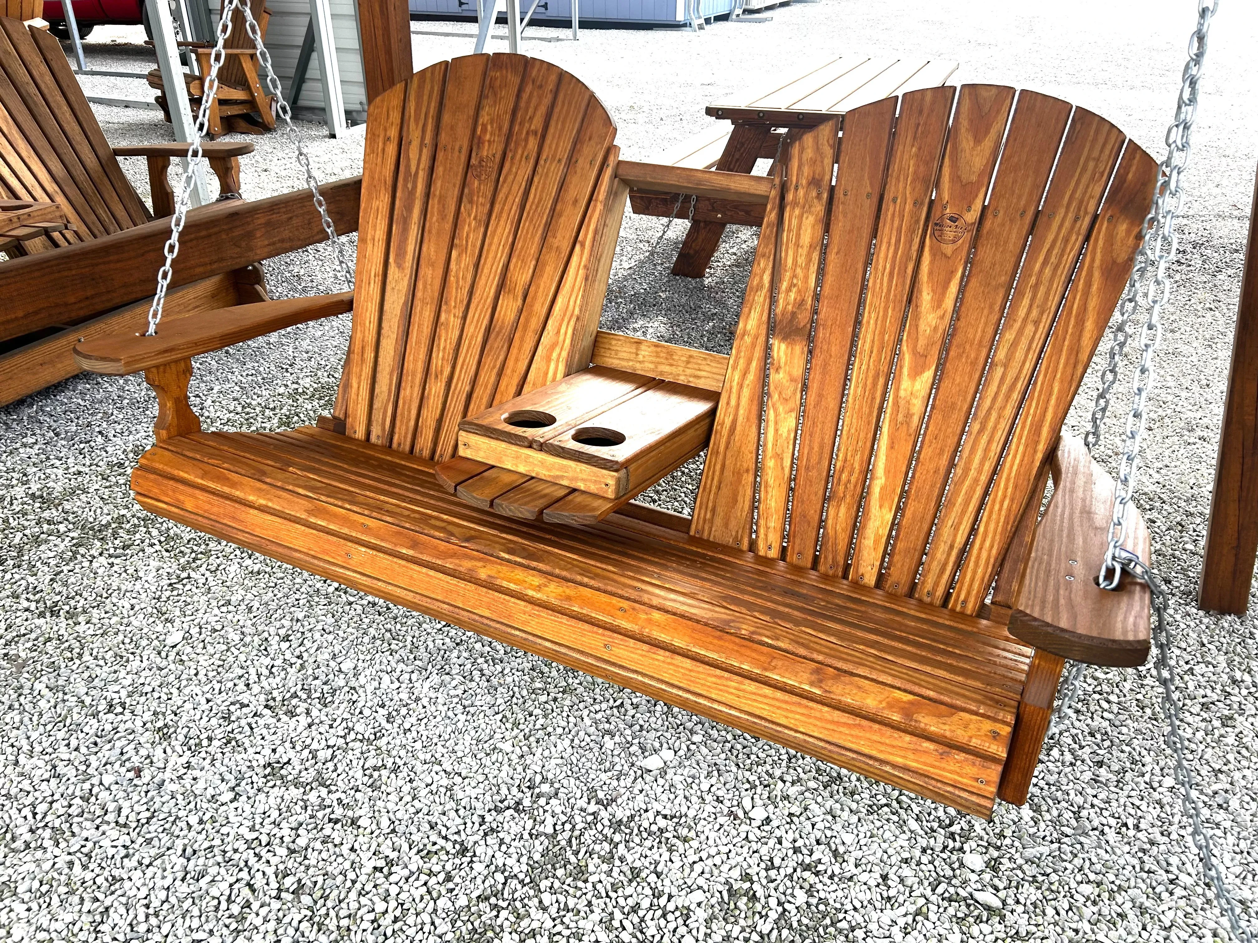 a wood bench swing that has been stained and sealed. It has a center console with 2 cupholders in the down position