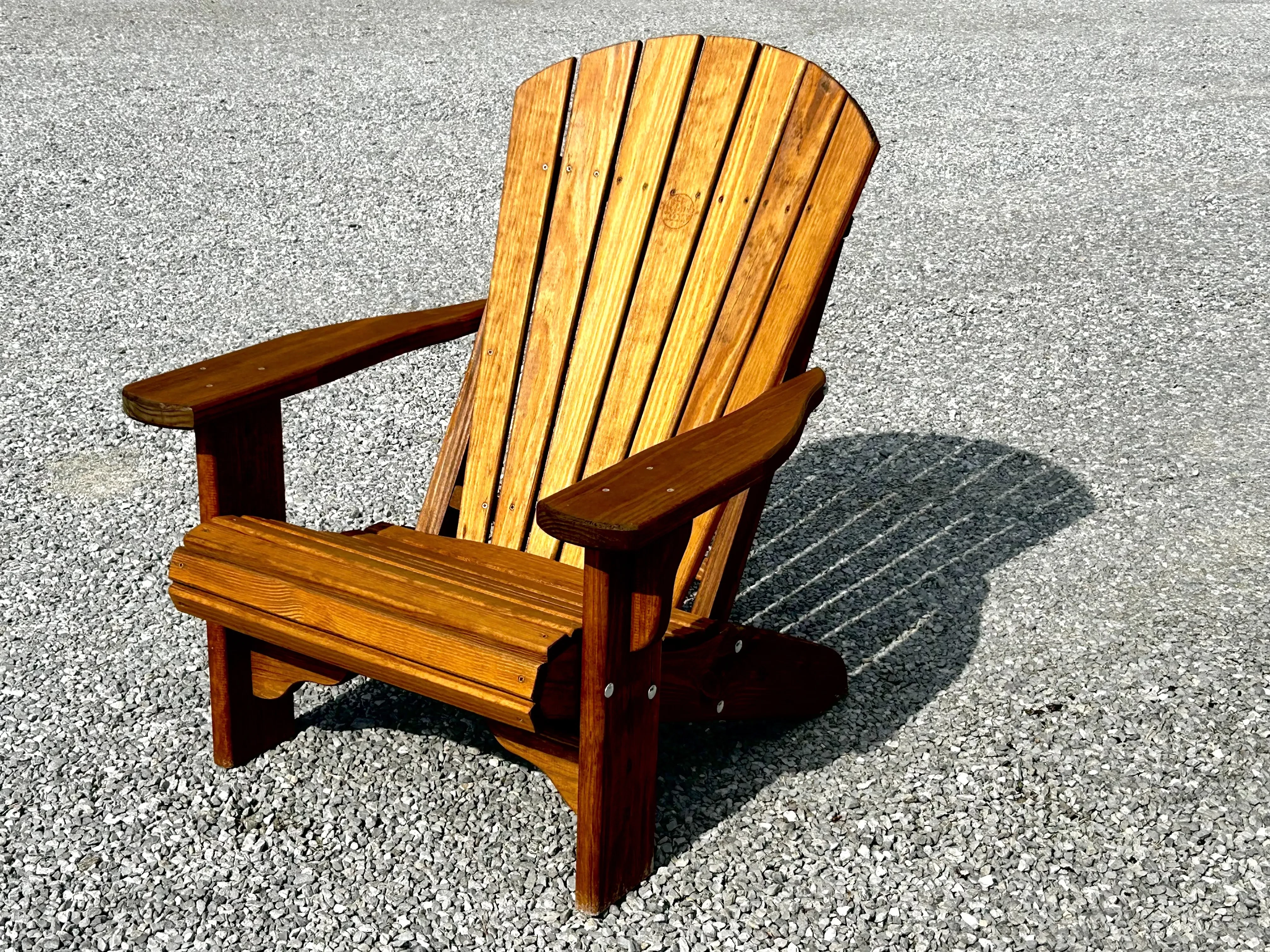 a wood chair sitting in the gravel. It is professionally stained and sealed to last a long time