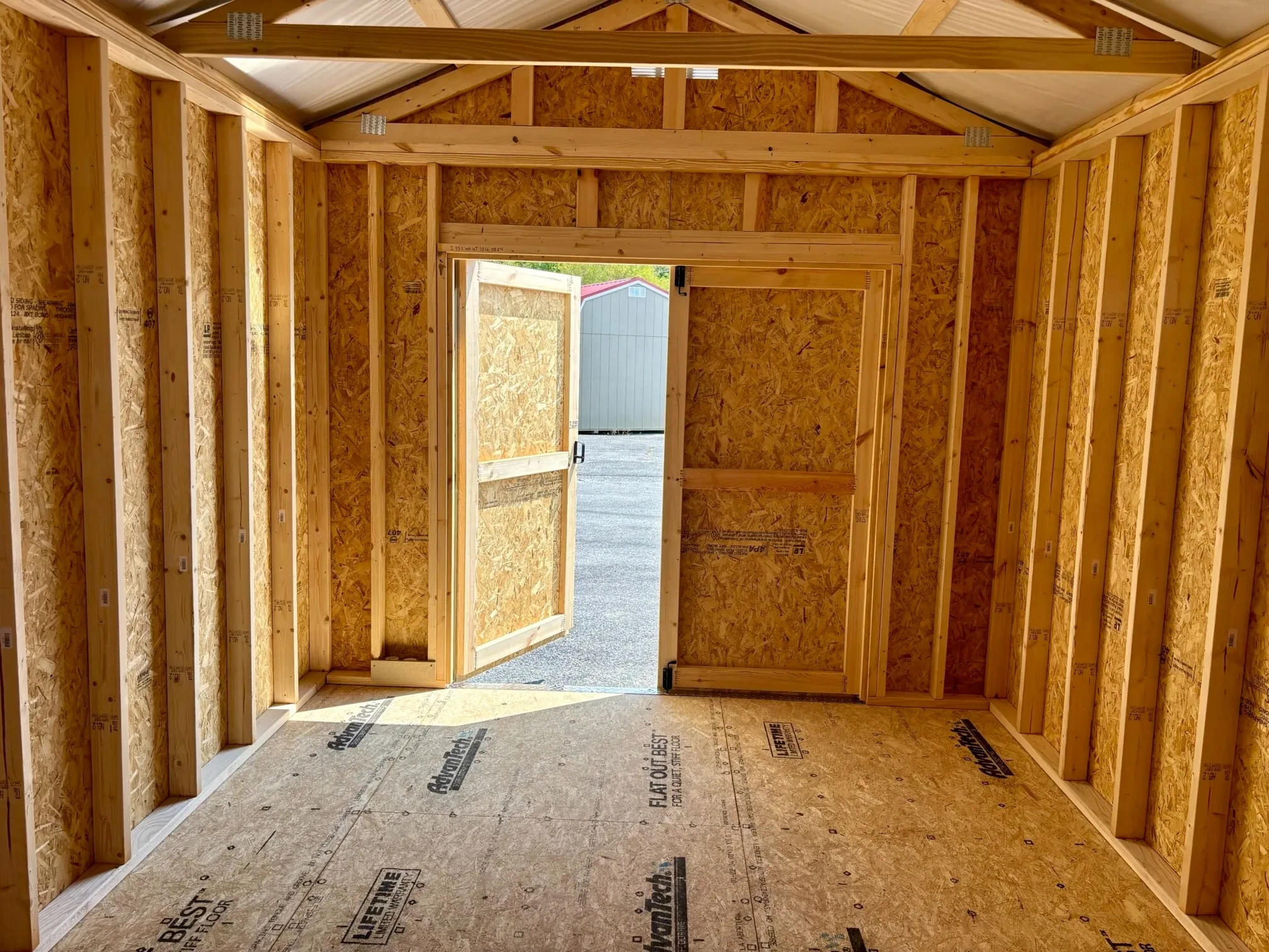 The inside of a wood shed showing double doors that are open.