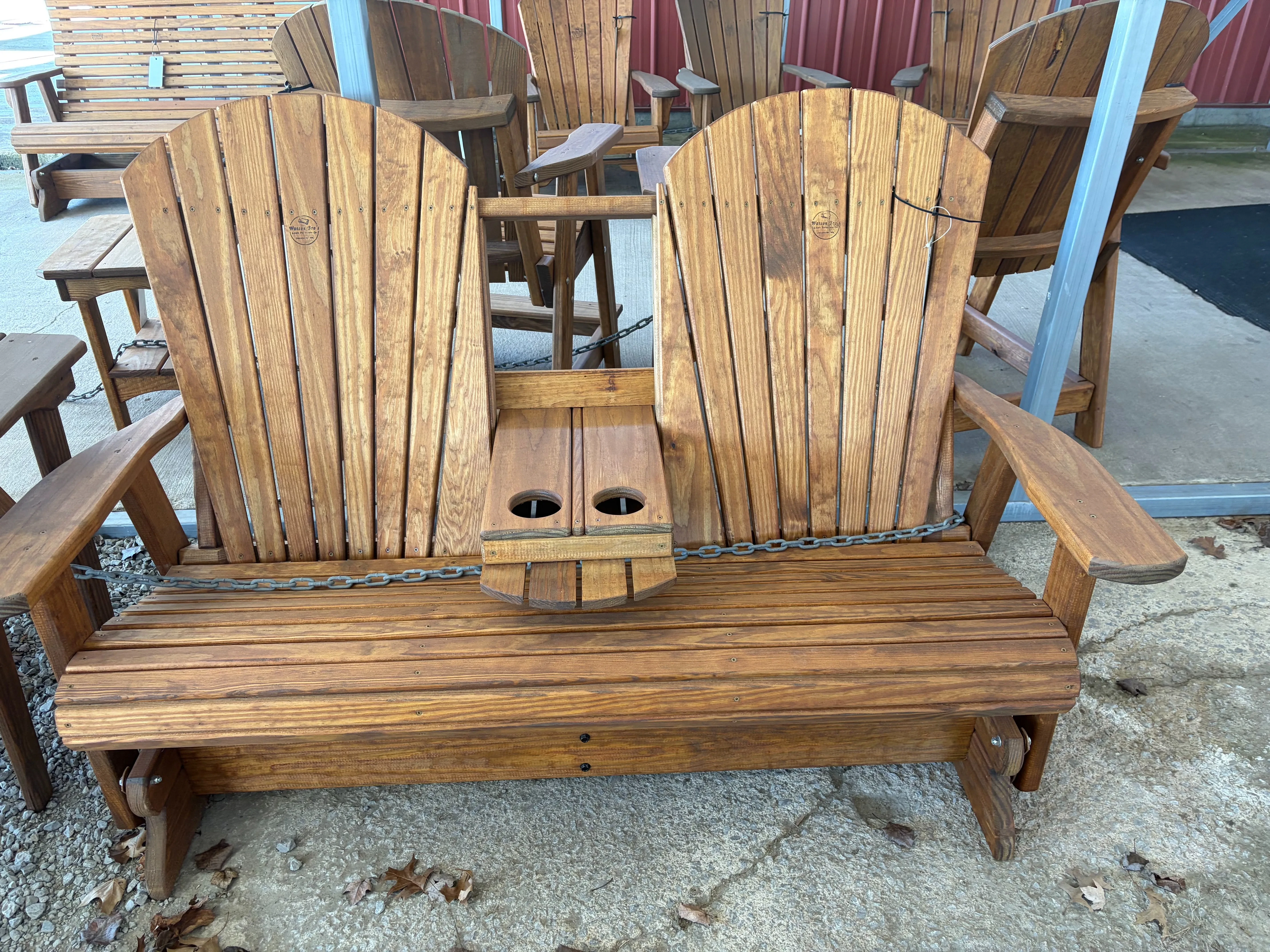 a wood bench that seats two. It has a center console with cupholders in the down position. It is stained and sealed