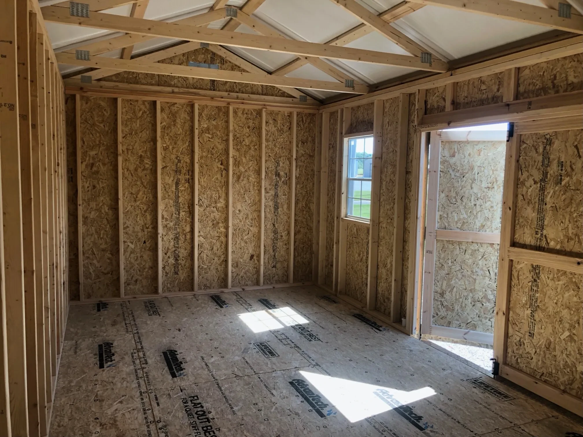 The inside of a wood garden shed showing one of the double doors being open