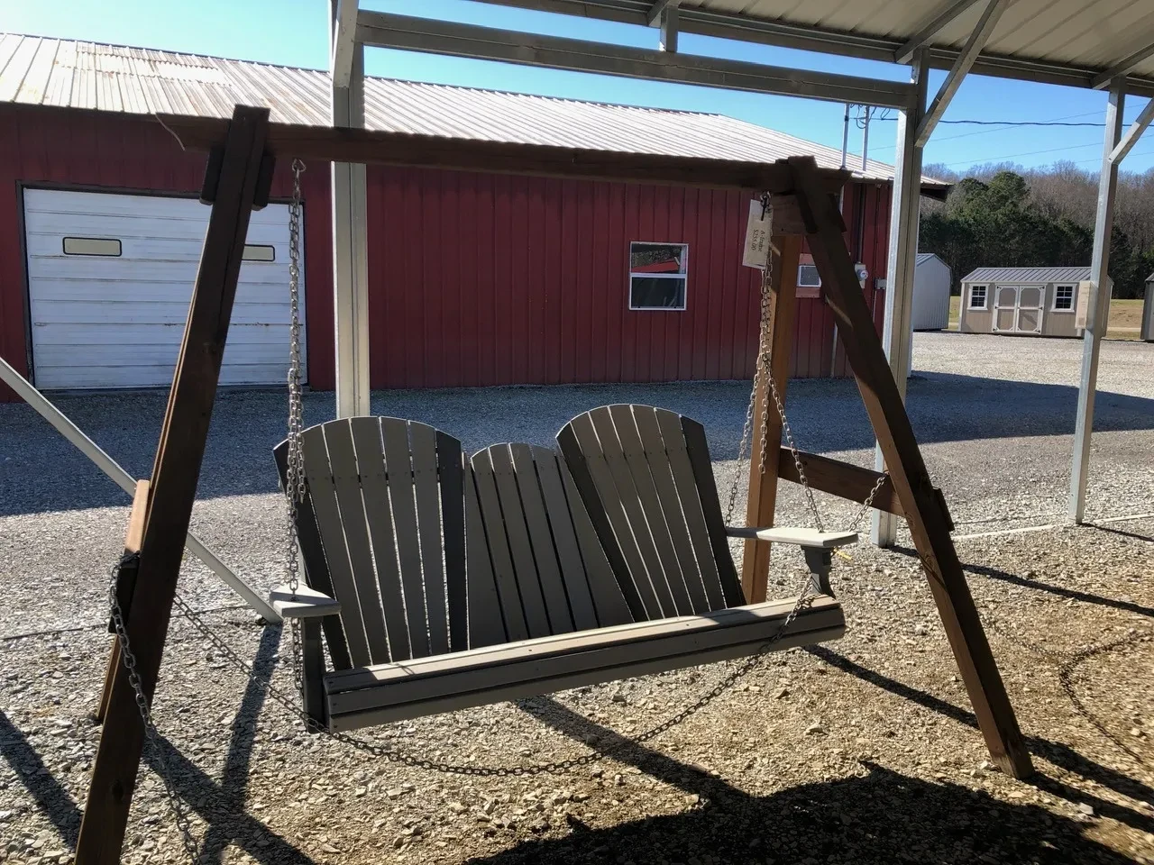 a polywood bench with a center console being held up by chains attached to an a-frame structure