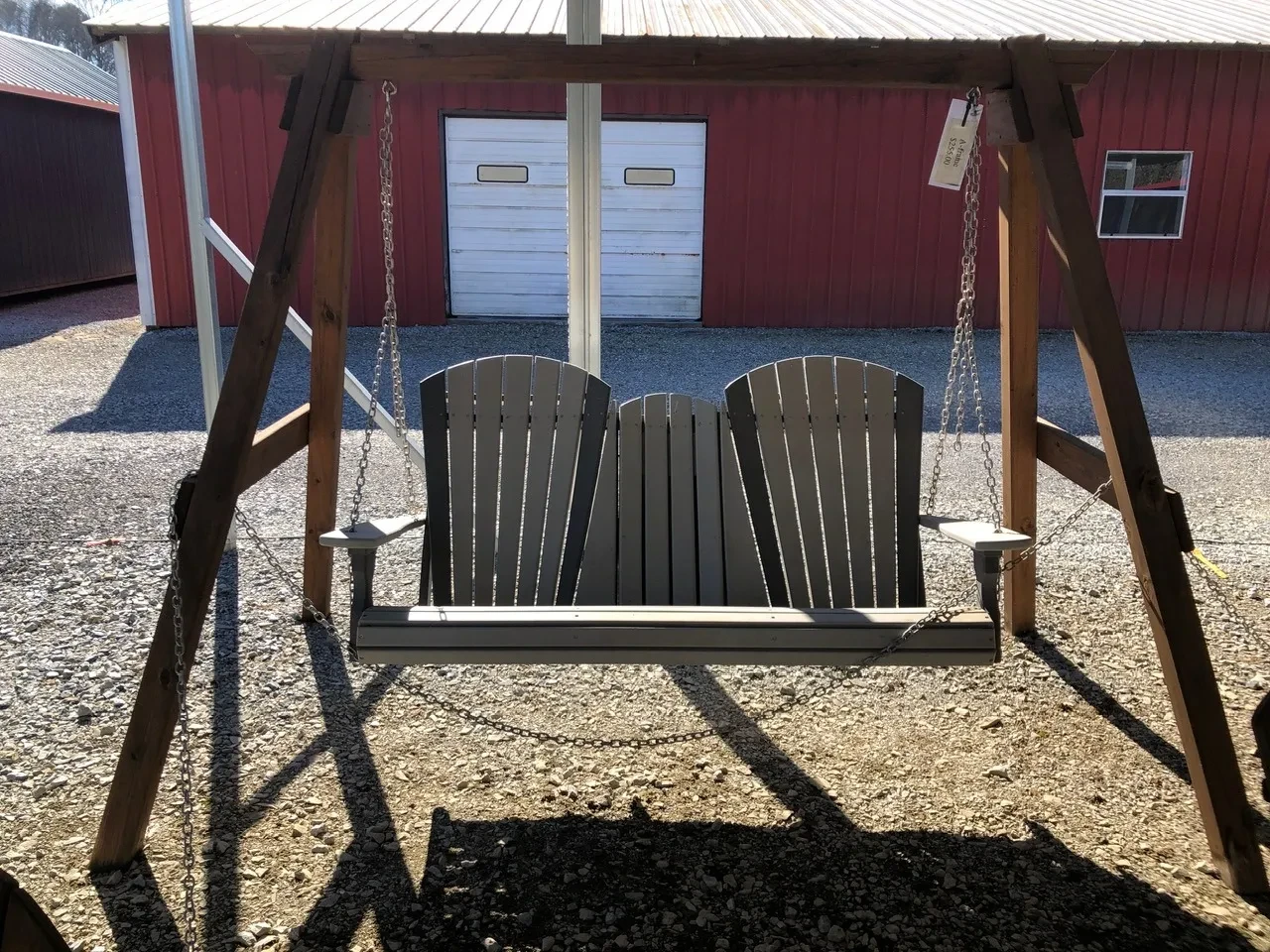 a bench made out of a polywood material being held up by chains to a wooden a-frame structure