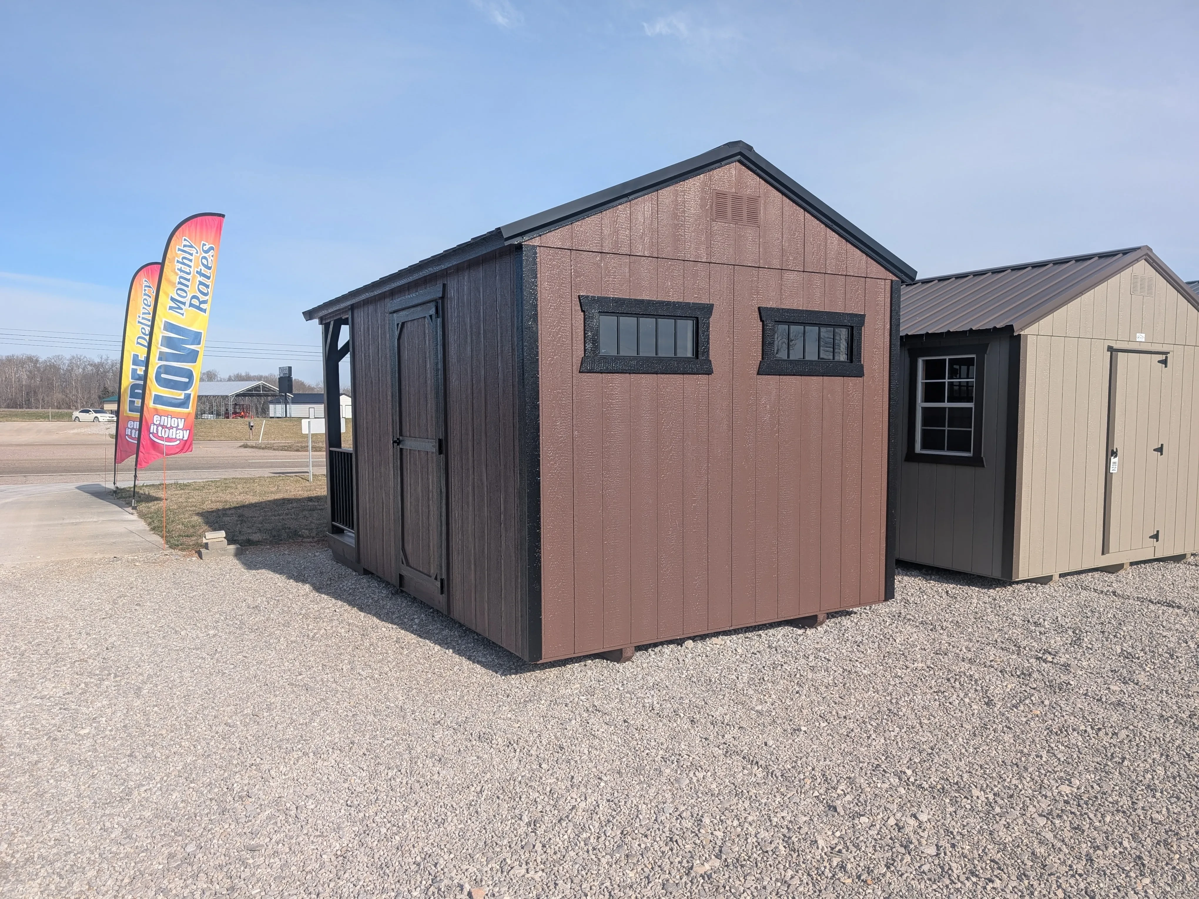 the back side of a brown cabin with black trim. The back wall has two transom windows in it side by side.