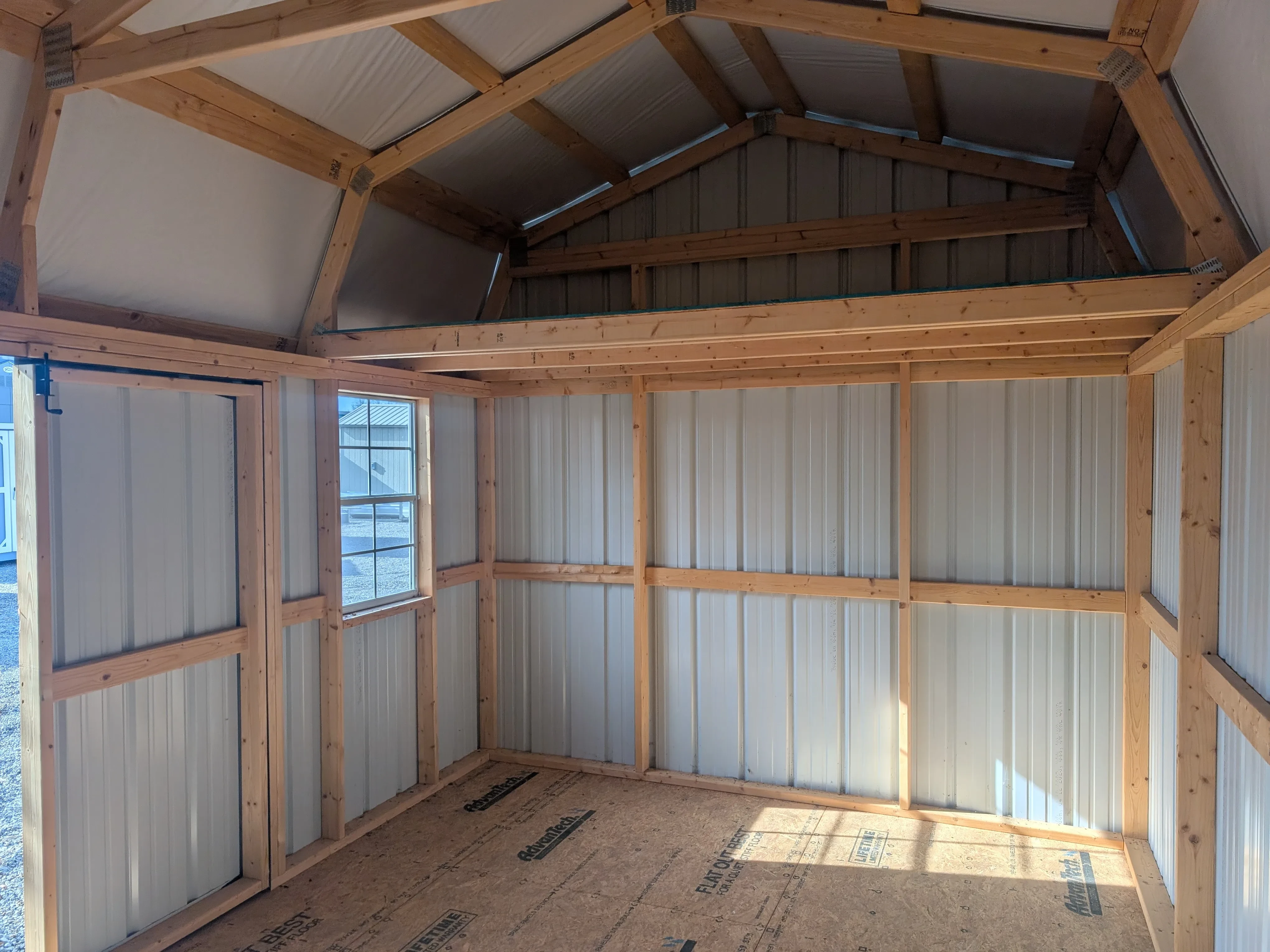 inside a metal side lofted shed looking at the left wall. It has a 4' loft. The front wall has a window
