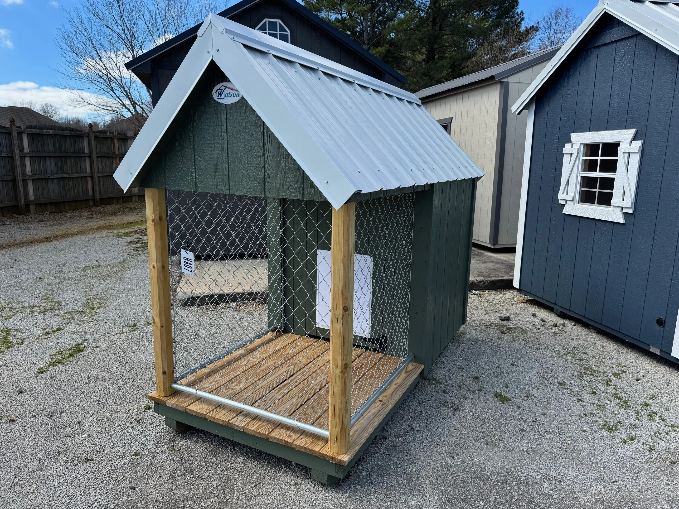 Front of 4X8 dog house, white roof and garland green body with walk in doggy door.