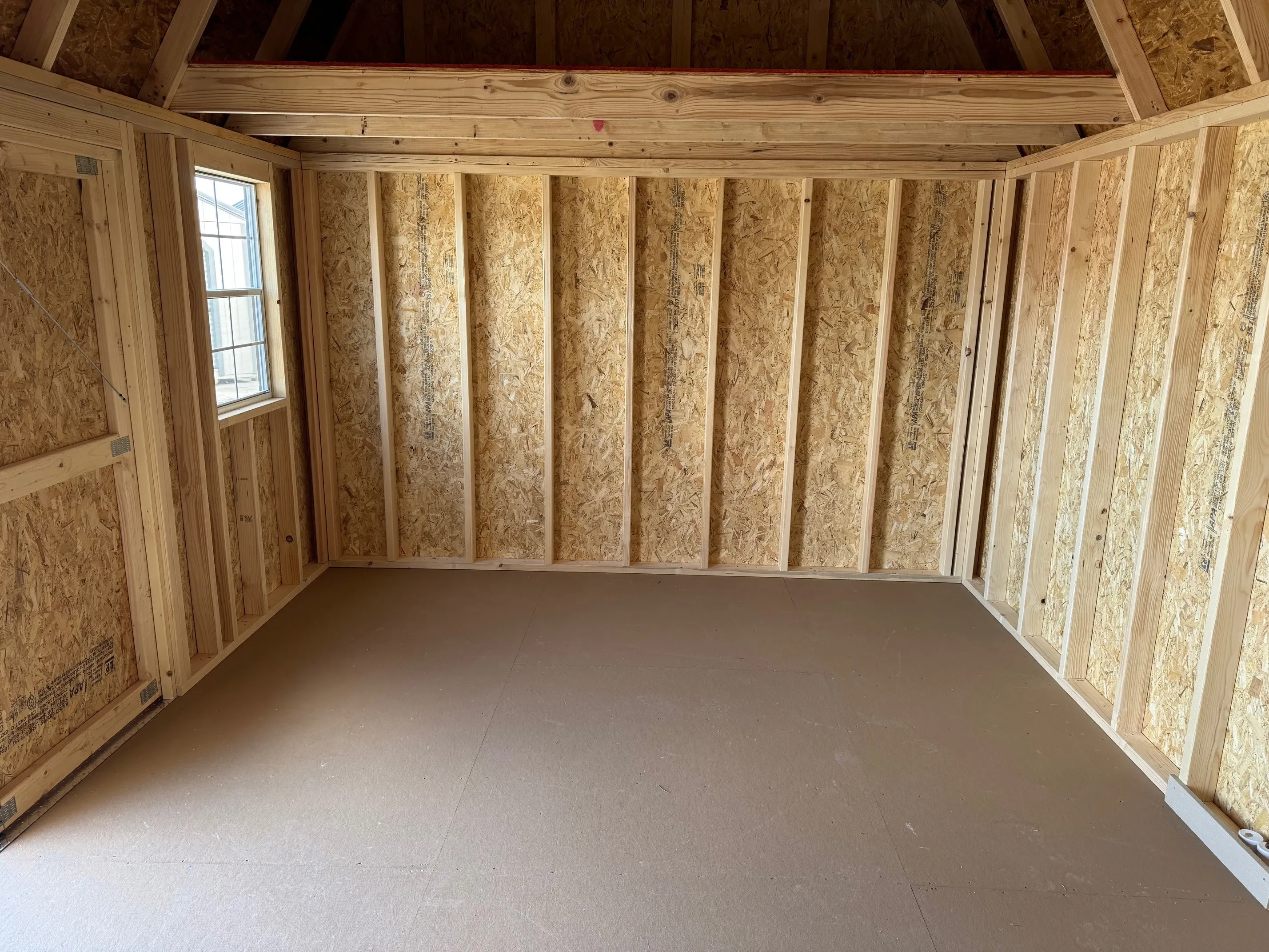 Inside of classic wood 12x16 side lofted barn with double doors and 2 windows