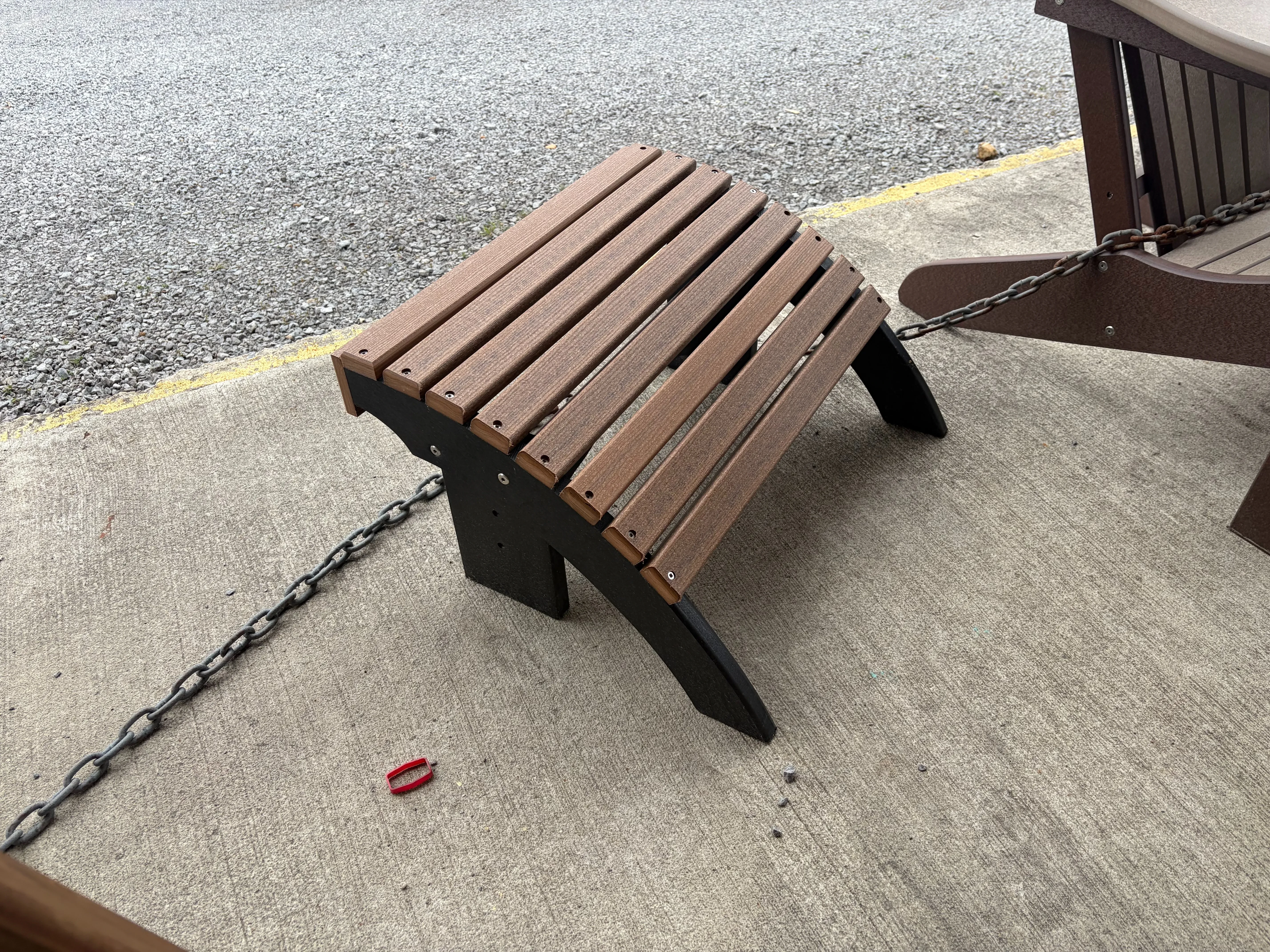 a foot stool made out of polywood sitting on concrete. It has 8 slats running horizontally