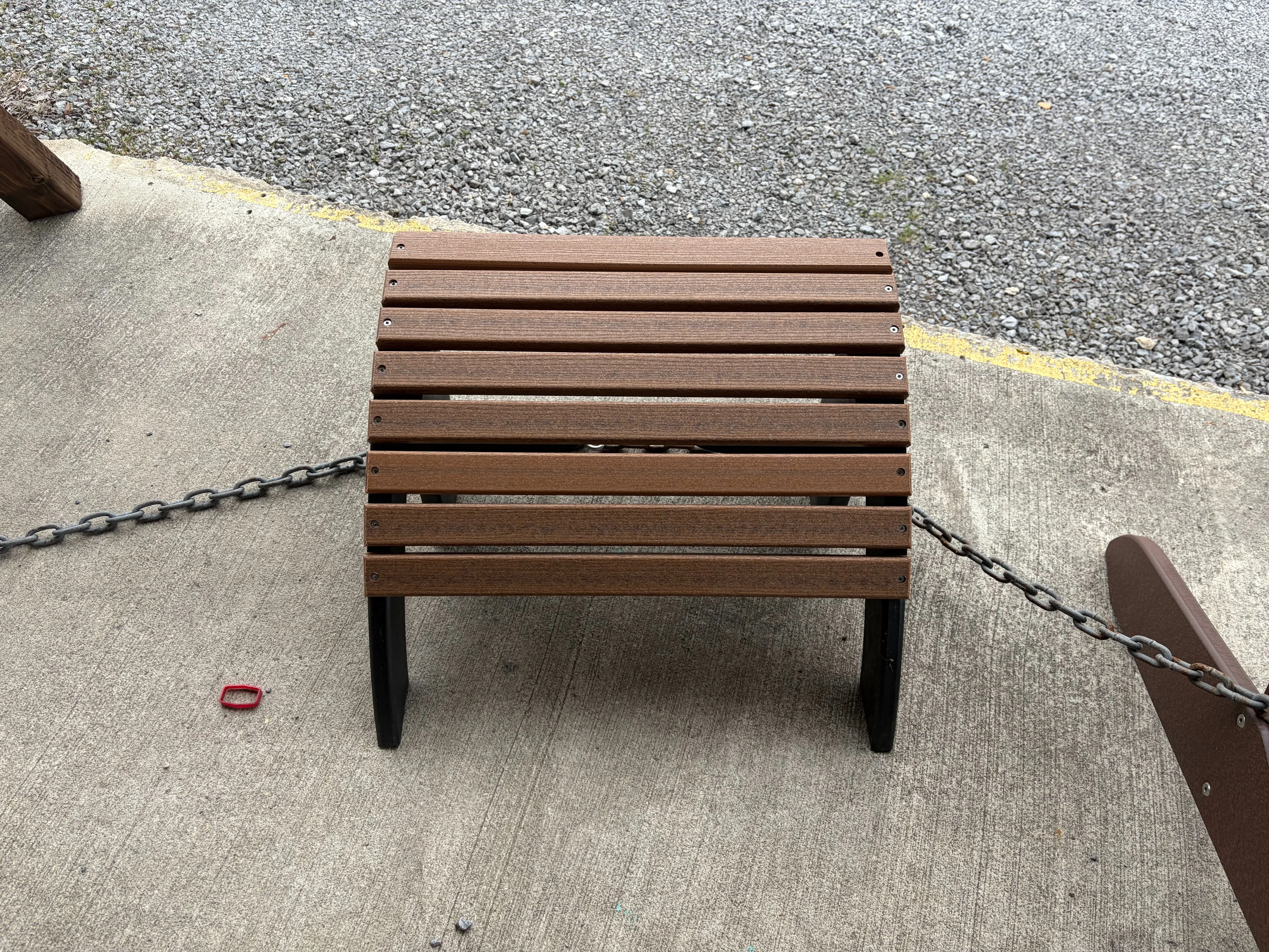a foot stool with 8 slats running across for feet to lay on. It is made out of a polywood material and sitting on concrete
