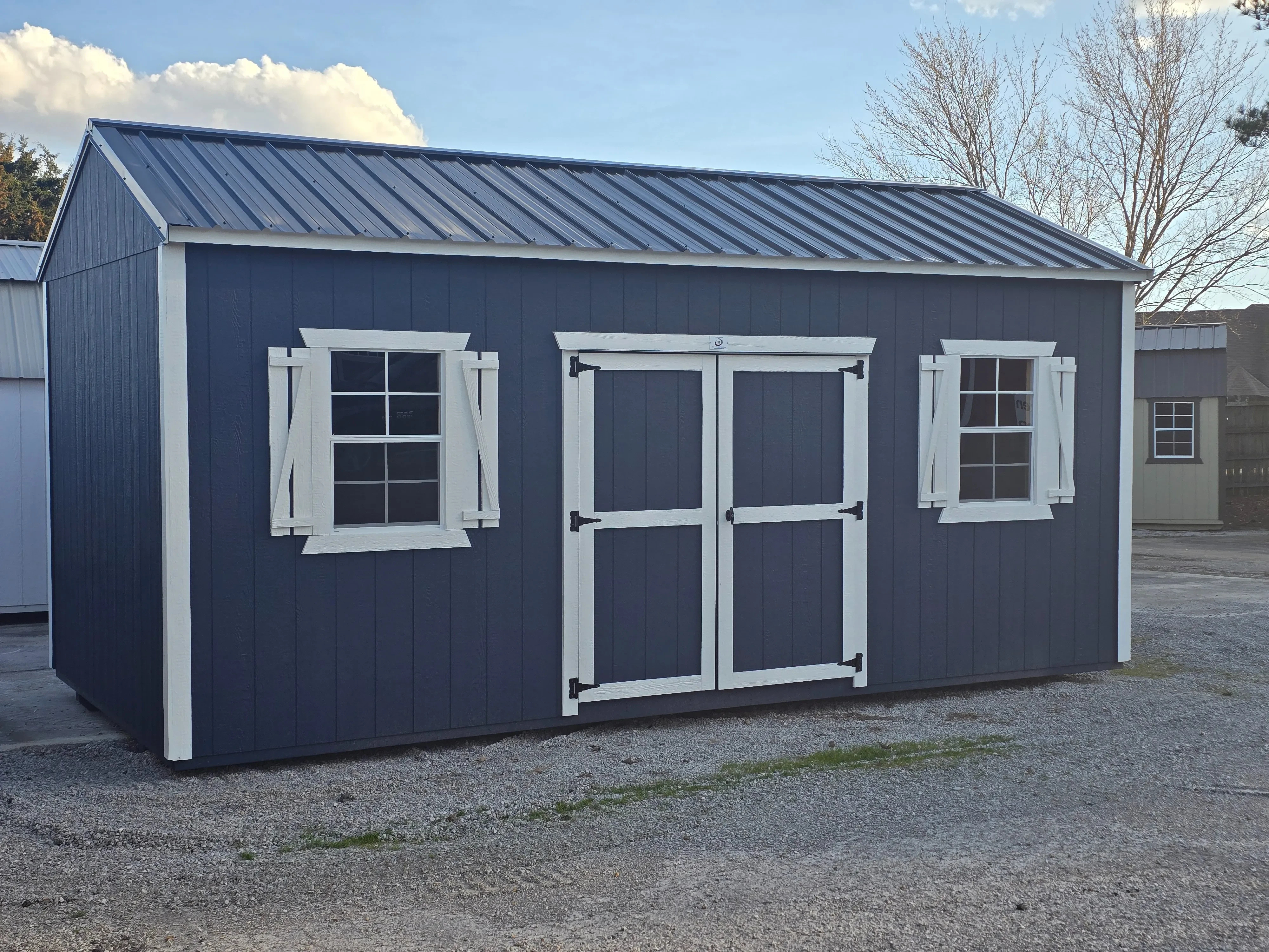 blue garden shed with two windows white trim