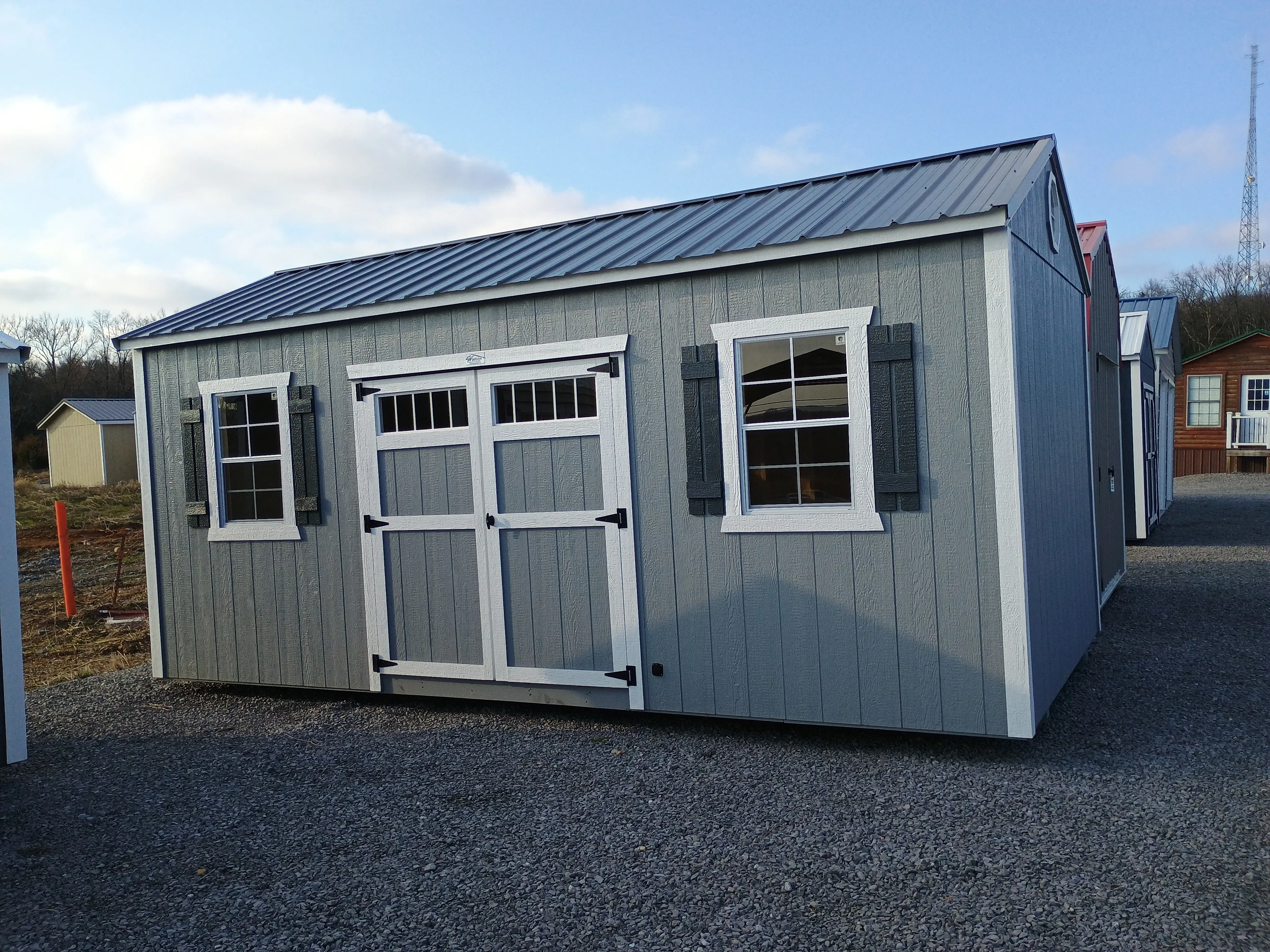 10x20 wood garden shed ext, lt gray and white trim, slate gray metal roof, transom windws, octagon windws, shutters, electric