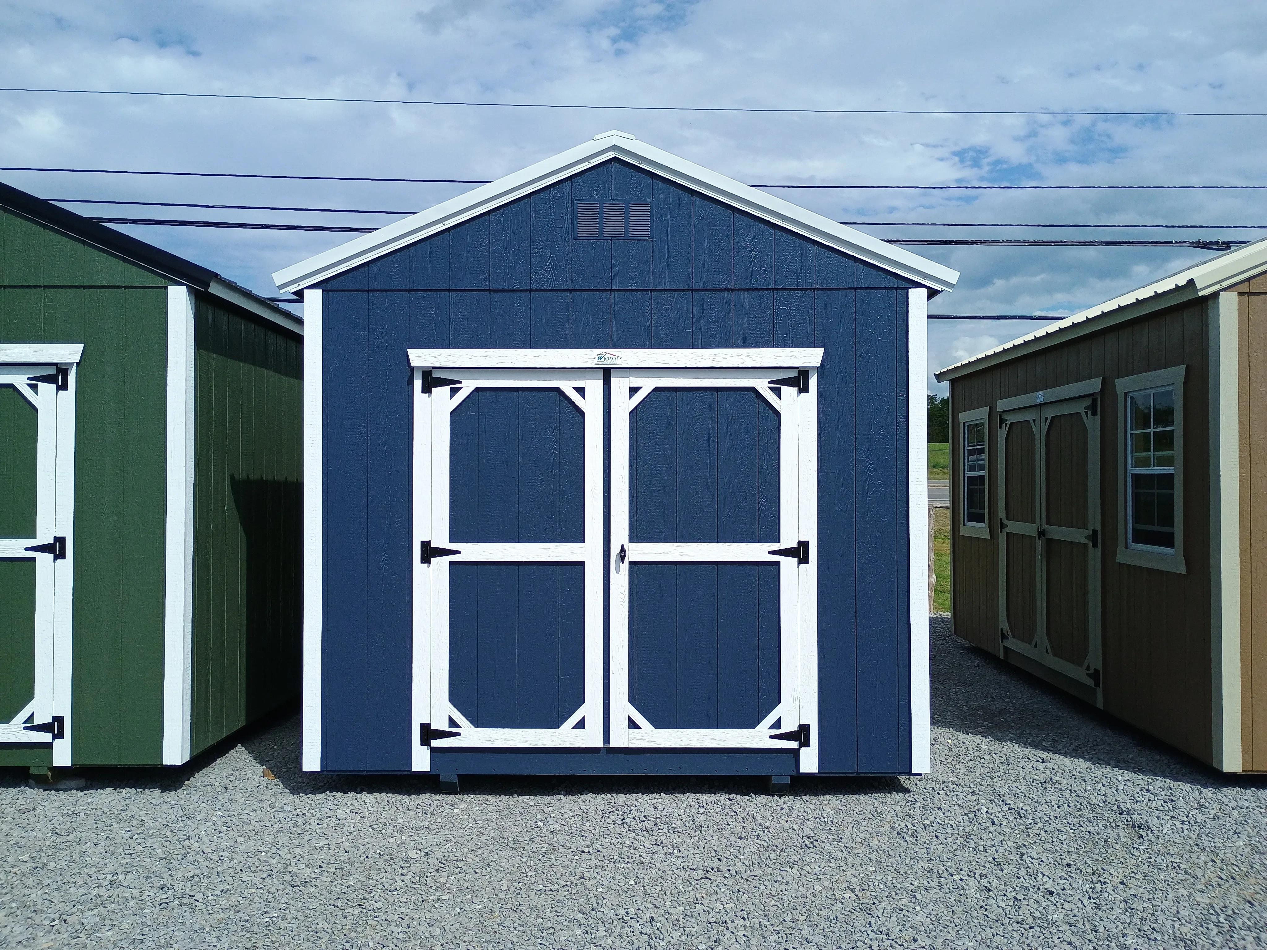 Outside of 10x12 Classic Wood Utility Shed with Double Doors, Painted Blue with White Trim, and White Metal Roof
