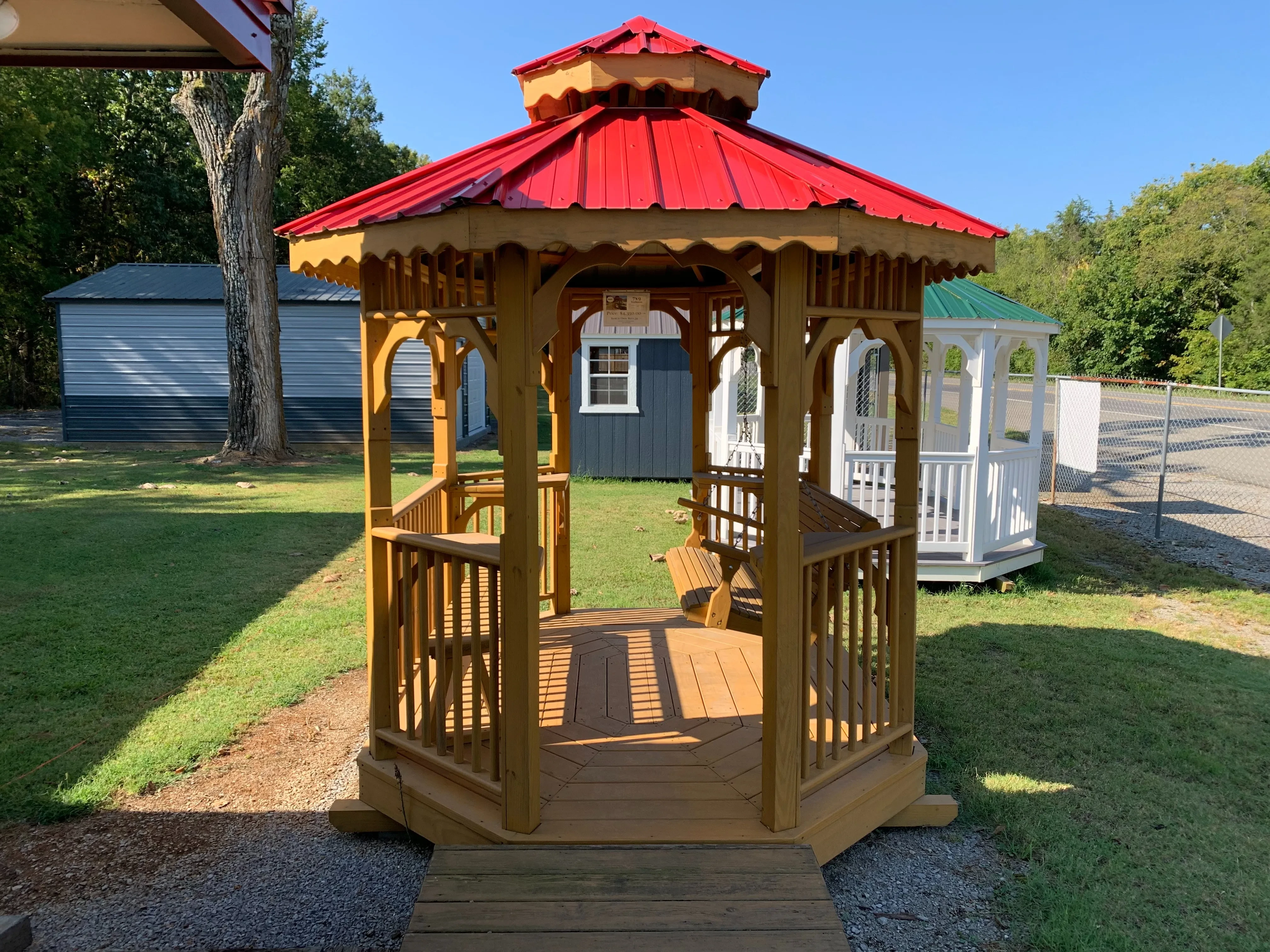 7x9 teahouse gazebo stained with red metal roof, swing and 4 side tables.