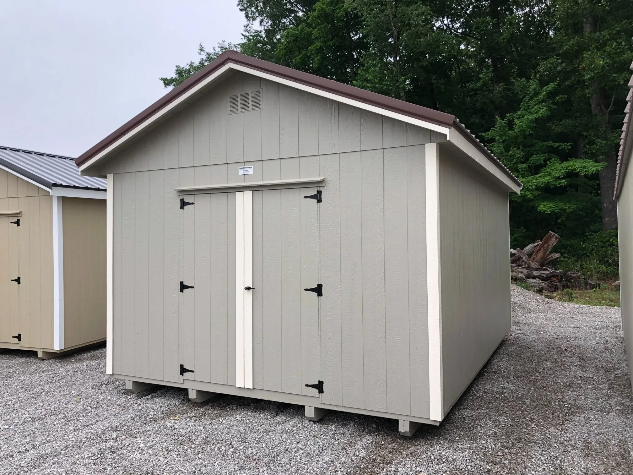 A gray wood shed showing the double doors