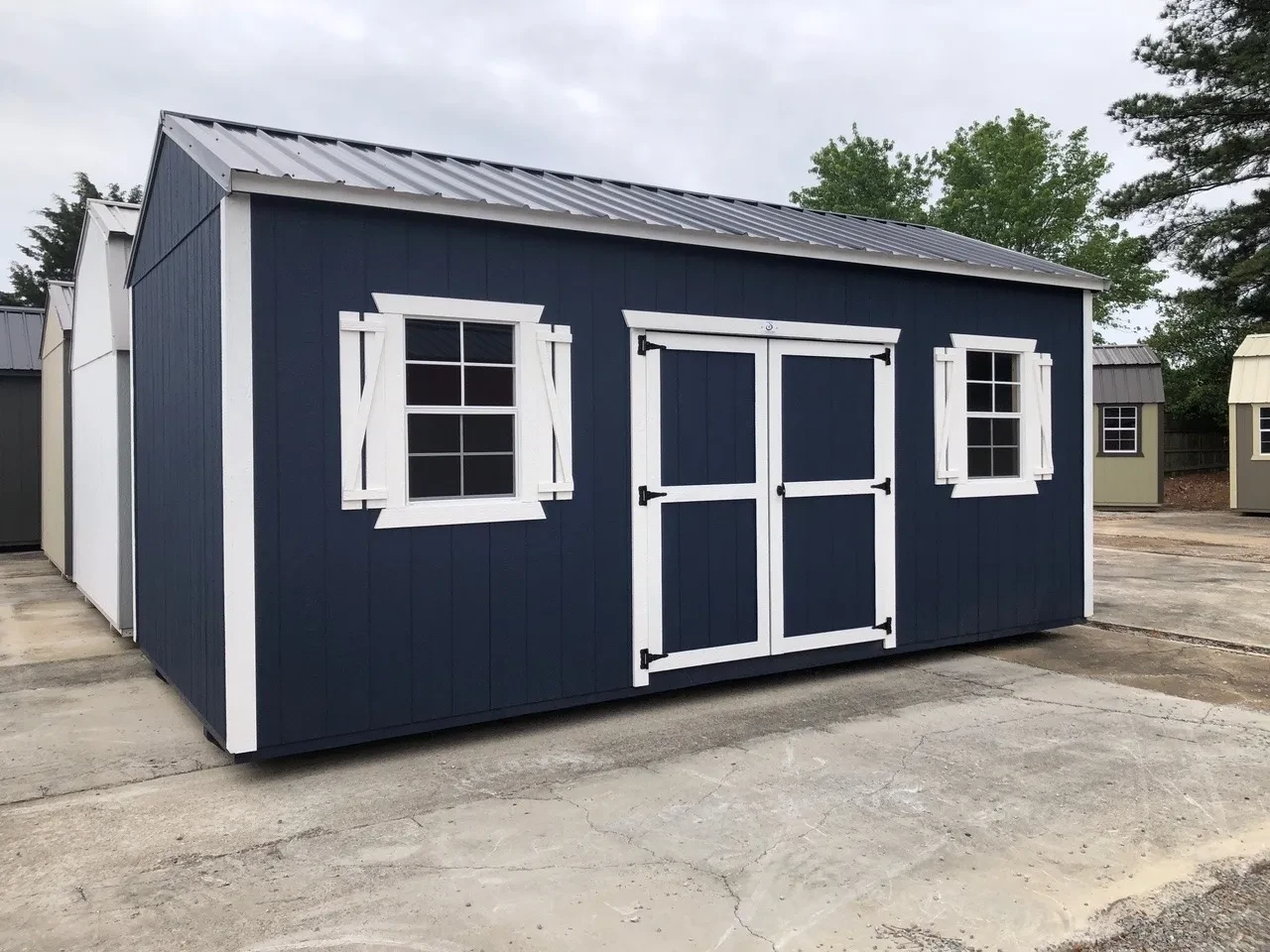exterior of blue shed showing side view with double doors and windows