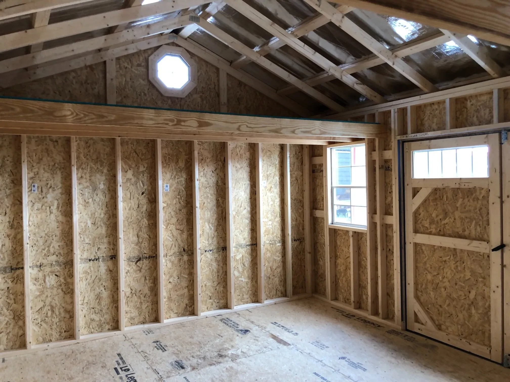 The inside of a wood shed showing a loft, octagon window, and a 2x3 window