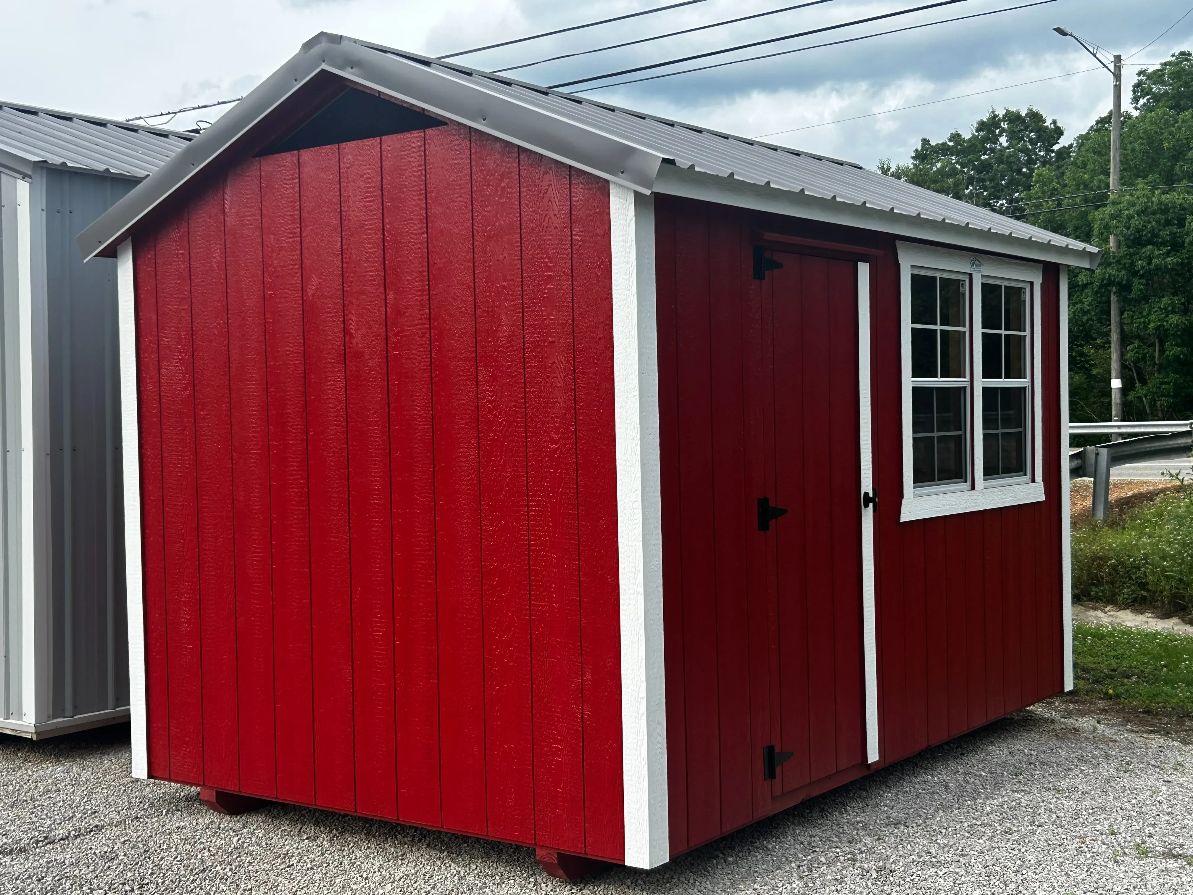Left side of an 8x12 chicken coop in mountain red with a charcoal metal roof