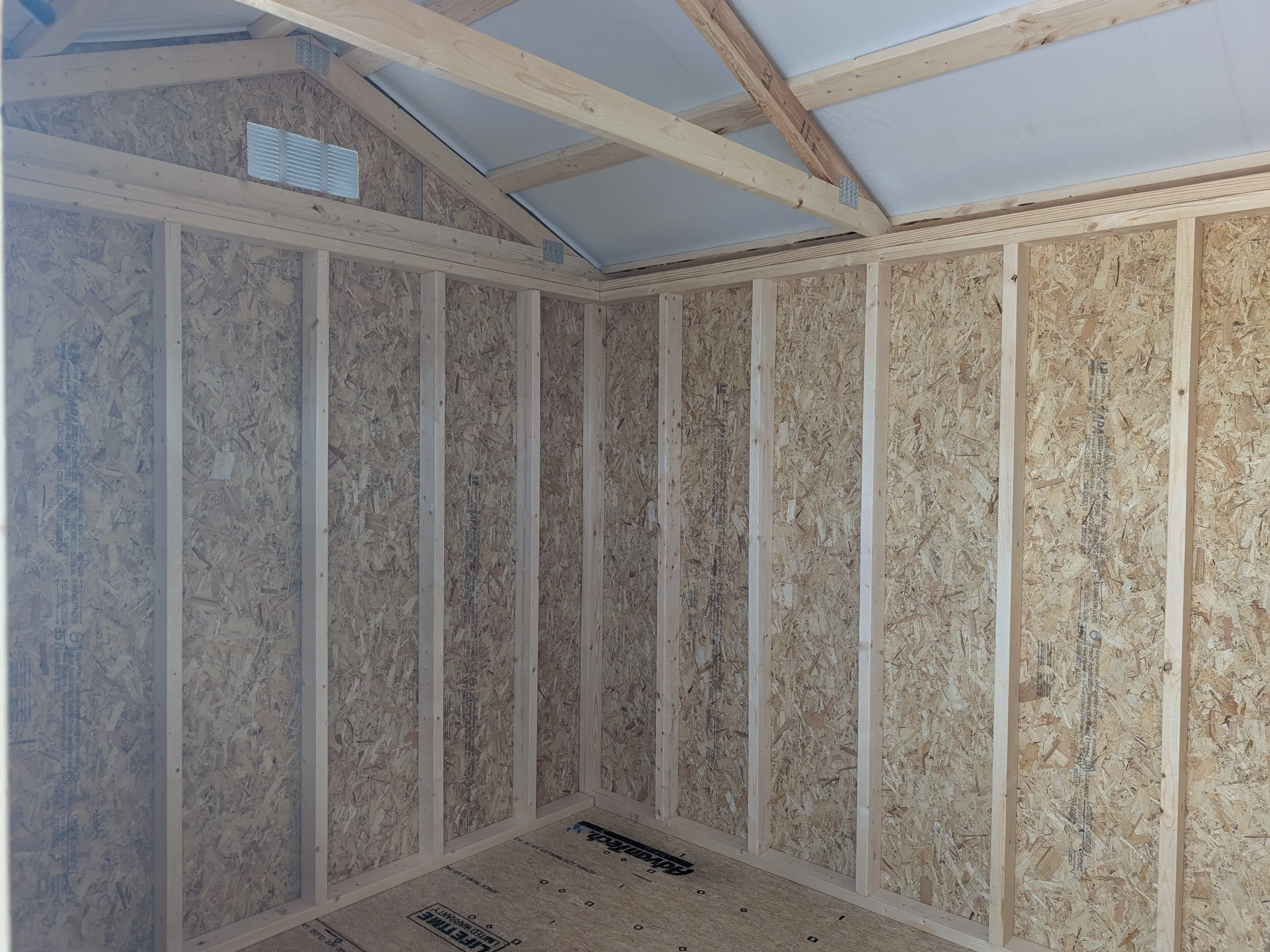 inside a wood garden shed looking at the corner of the inside.