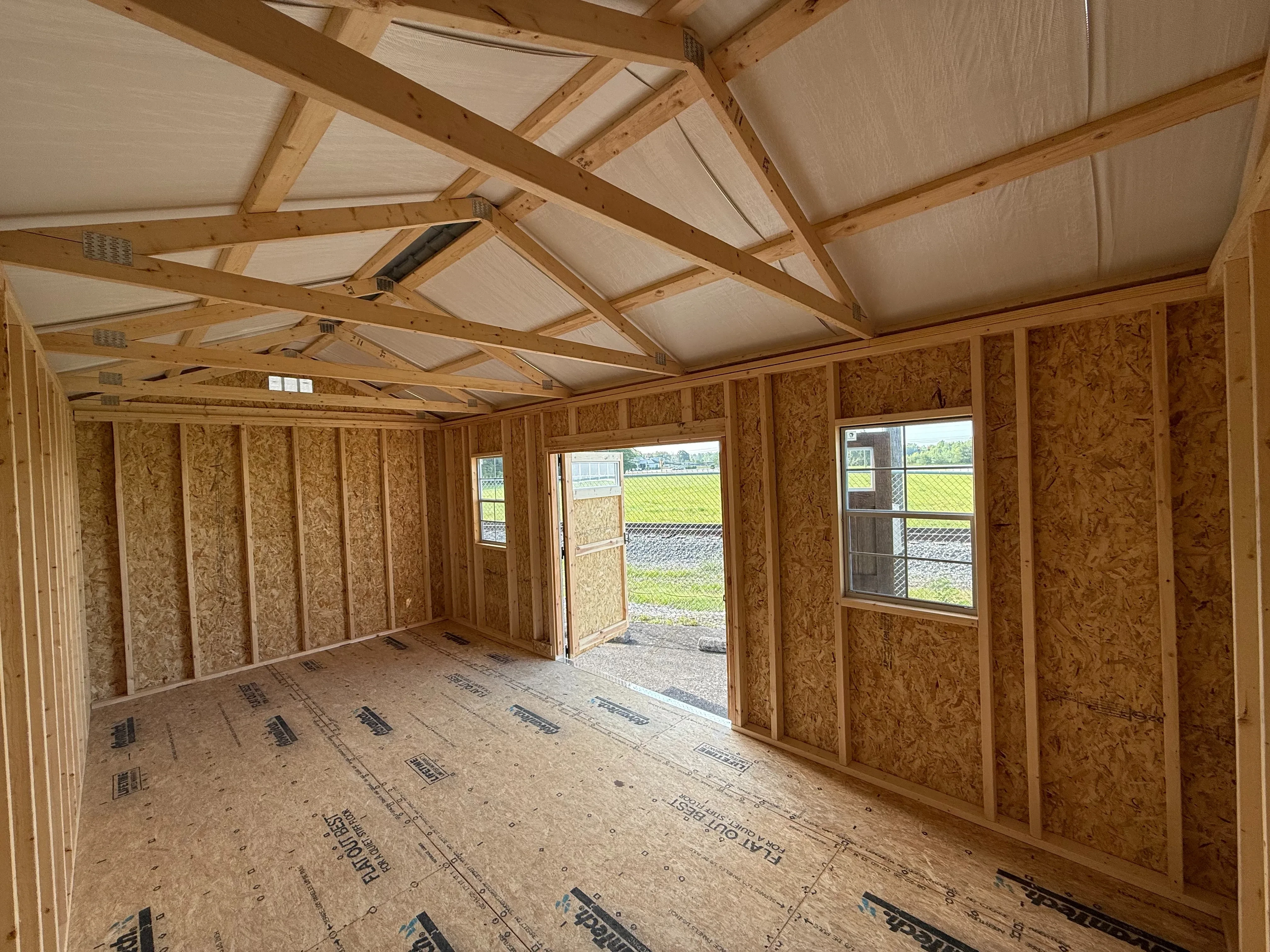 inside a 10x20 wood garden shed looking at the front where the double doors are. There are two 2x3 windows in the front