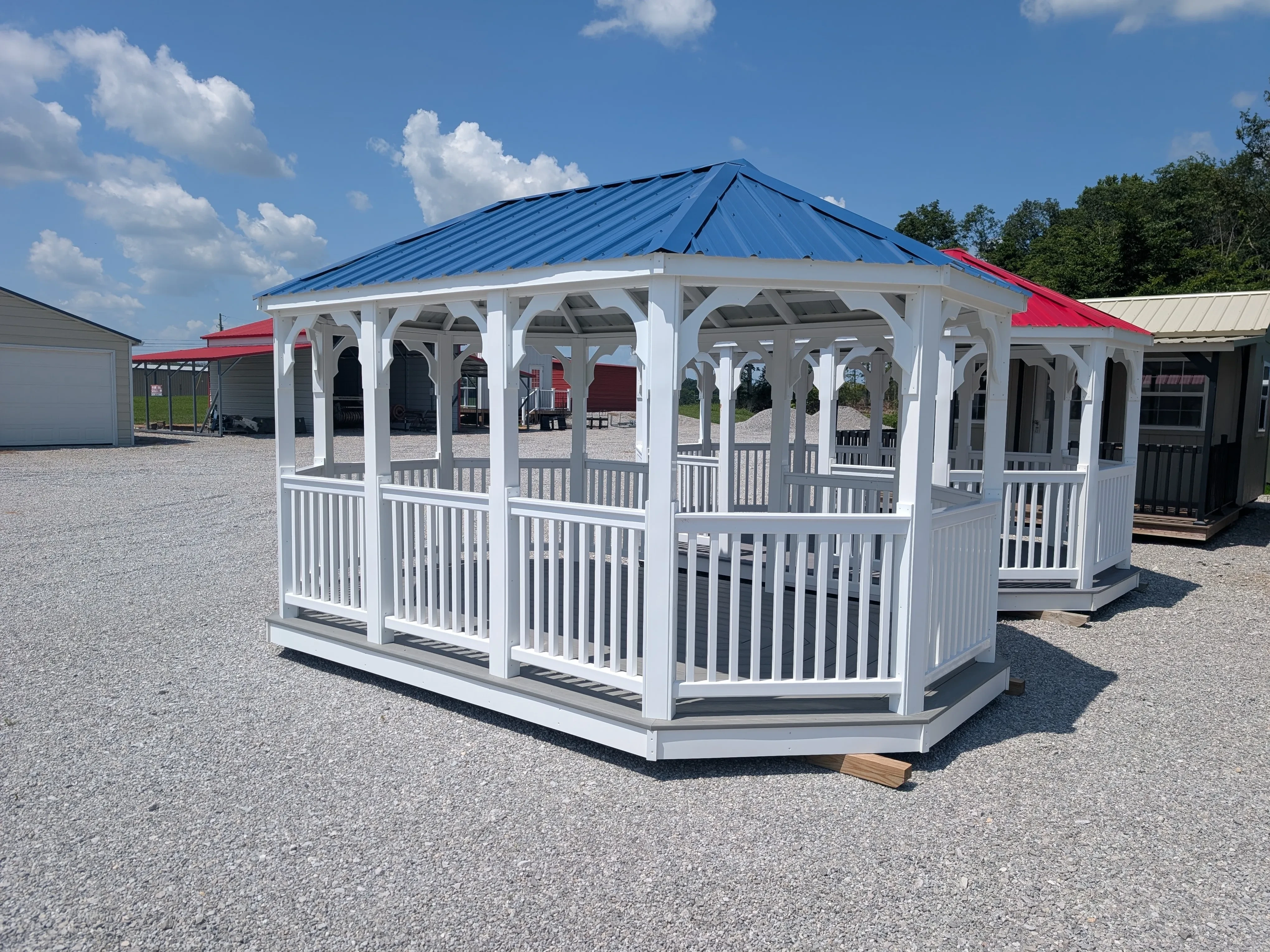 a white vinyl gazebo with posts and rails and a blue metal roof