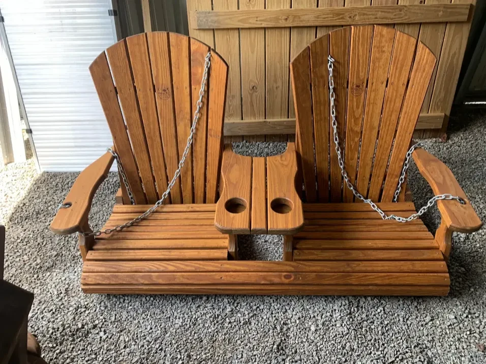 a wood stained and sealed swing with a center console in the middle that is stationary