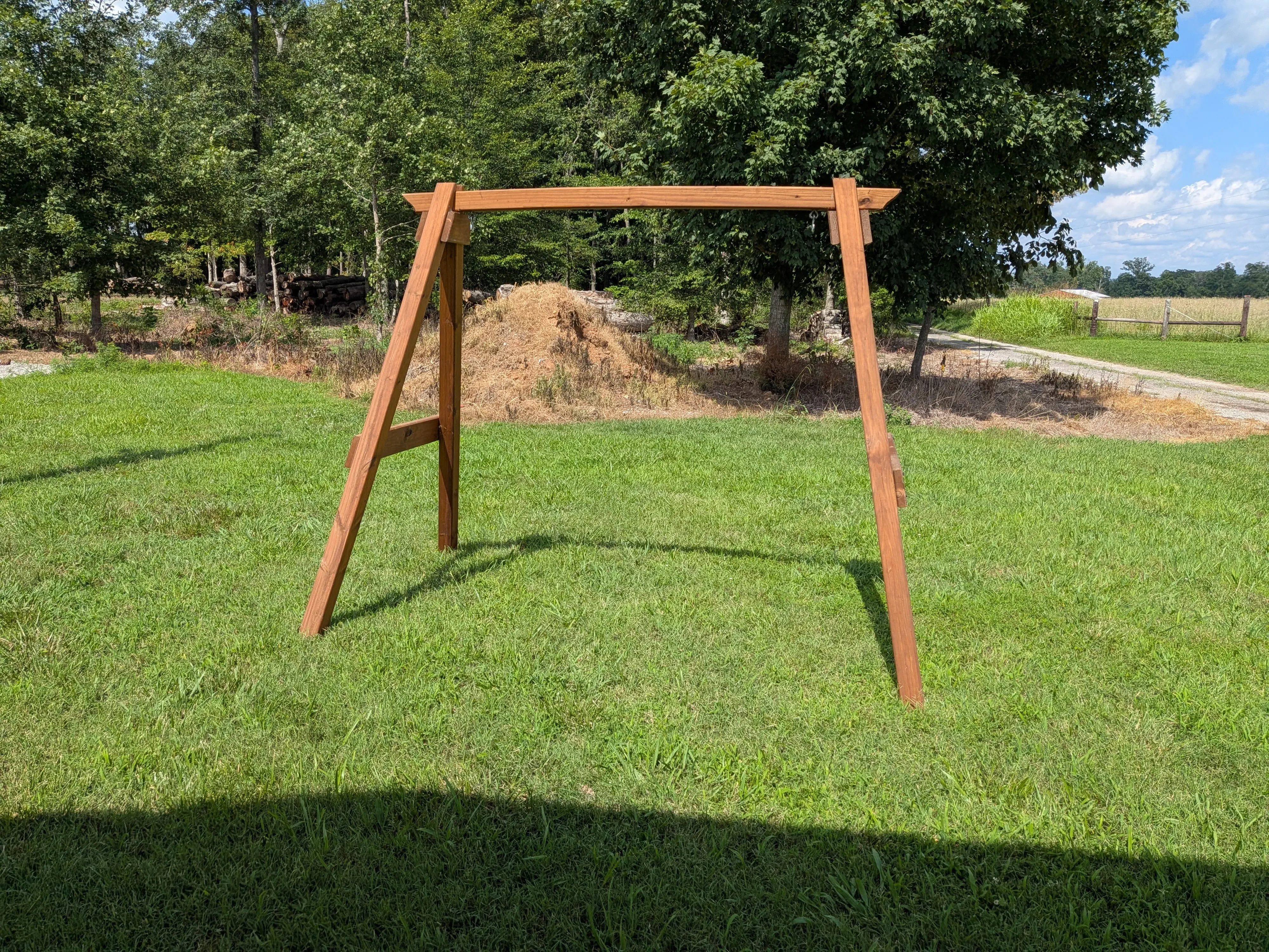 a wooden a-frame structure standing in the grass