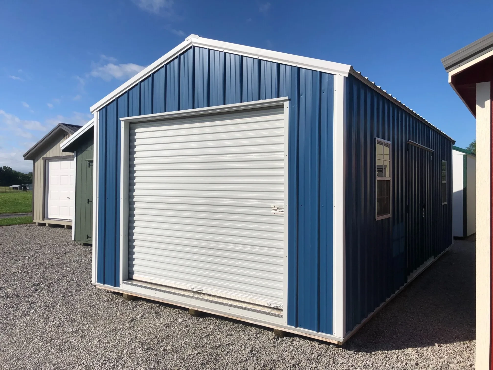 A blue metal garage shed showing the rollup door in the front