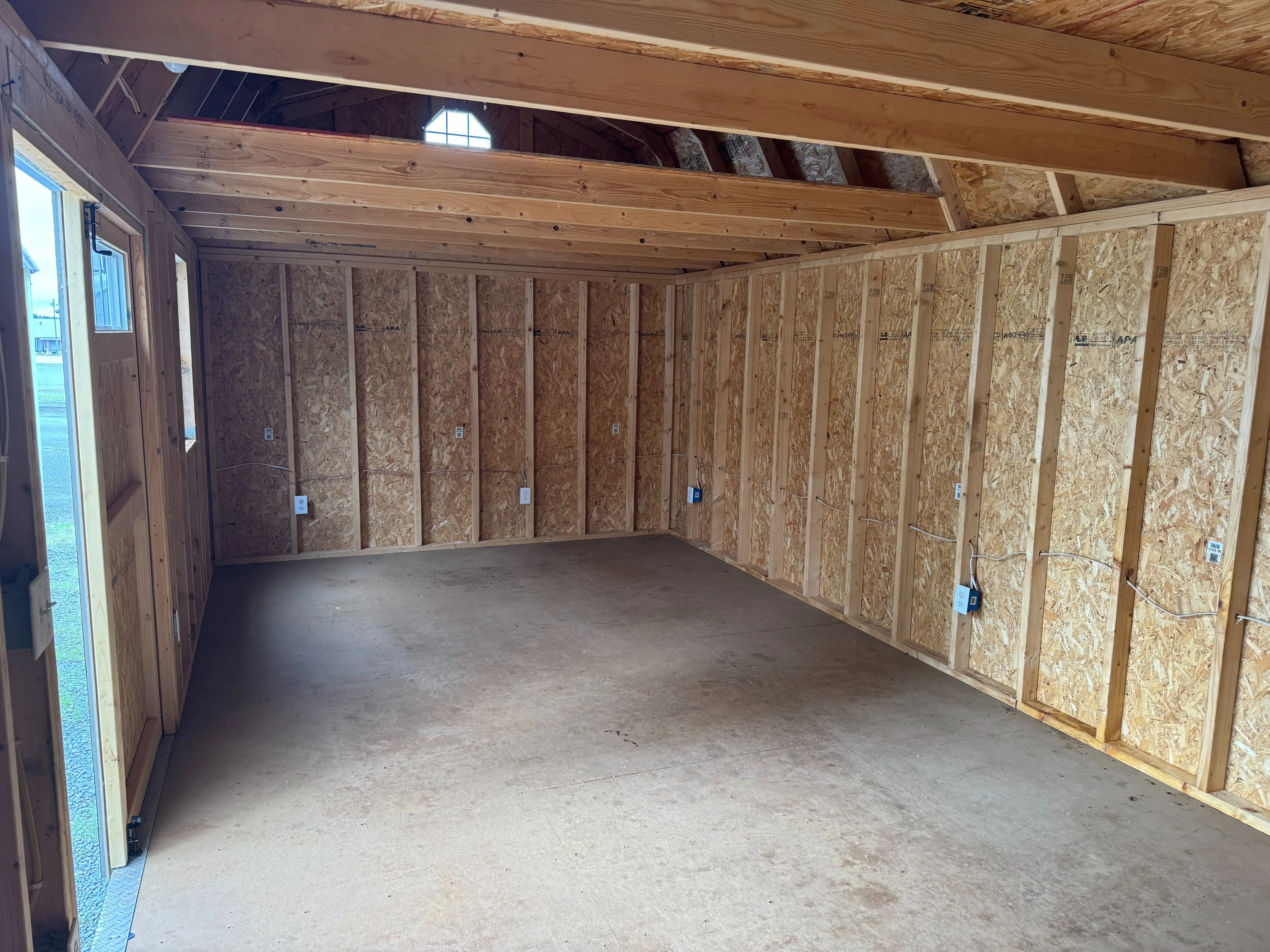 inside a large side lofted barn looking at the left wall. It has a large loft and electrical wiring