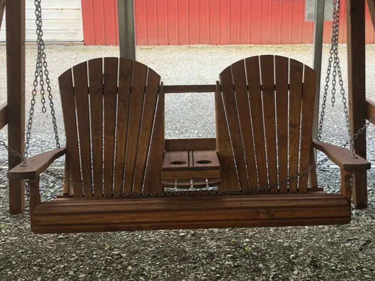 a wood stained and sealed swing with a center console that flips up and down