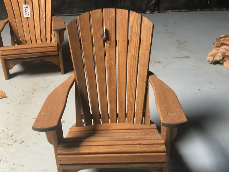 a wood stained and sealed chair sitting inside a room next to another wood chair