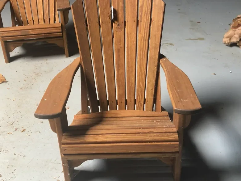 a chair sitting inside a room with good lighting. It is wood and it is stained and sealed
