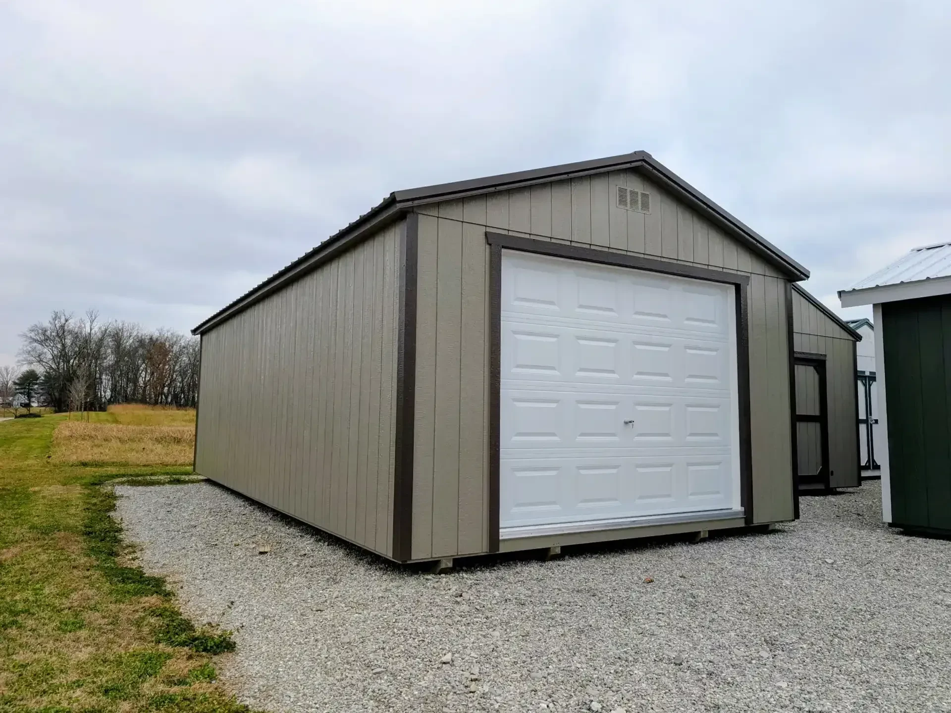 A wood garage shed with a garage door in the front