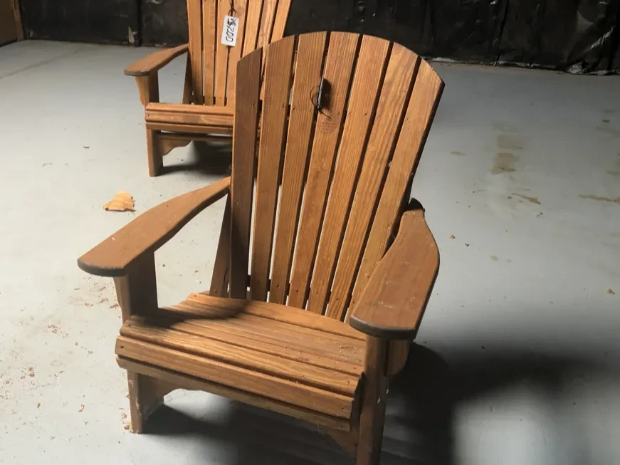 a wood stained and sealed chair sitting in a room next o another chair that is wood.