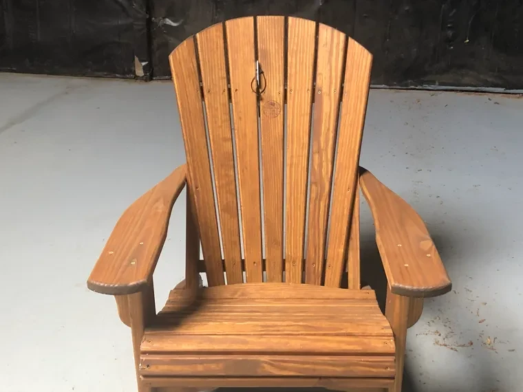 a wood chair sitting in a room by itself. It is stained and sealed professionally.