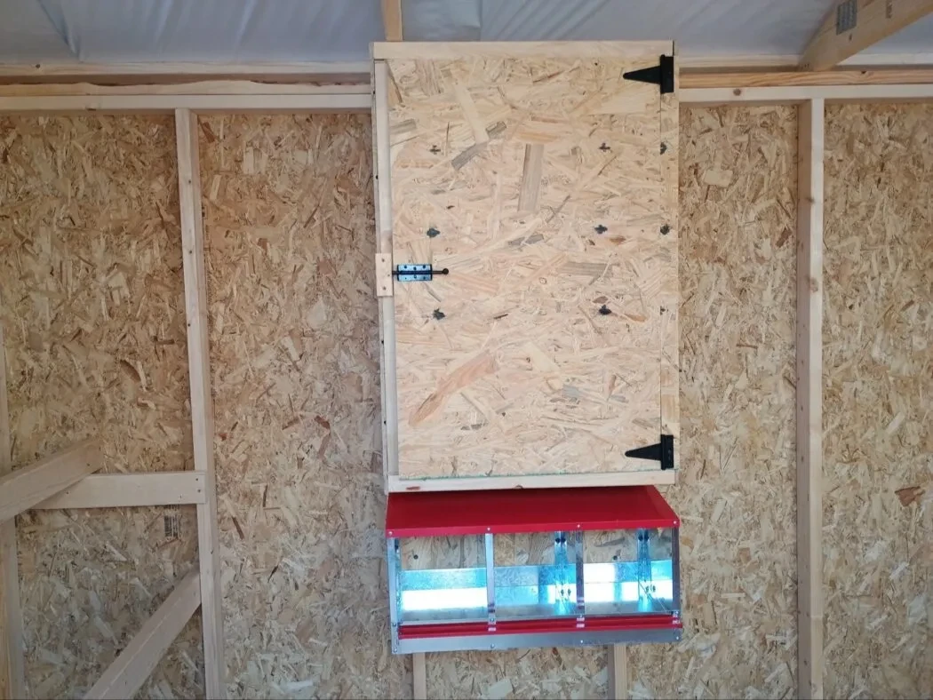 Inside of 8x12 chicken coop, showing 3 nesting boxes and feed cabinet.