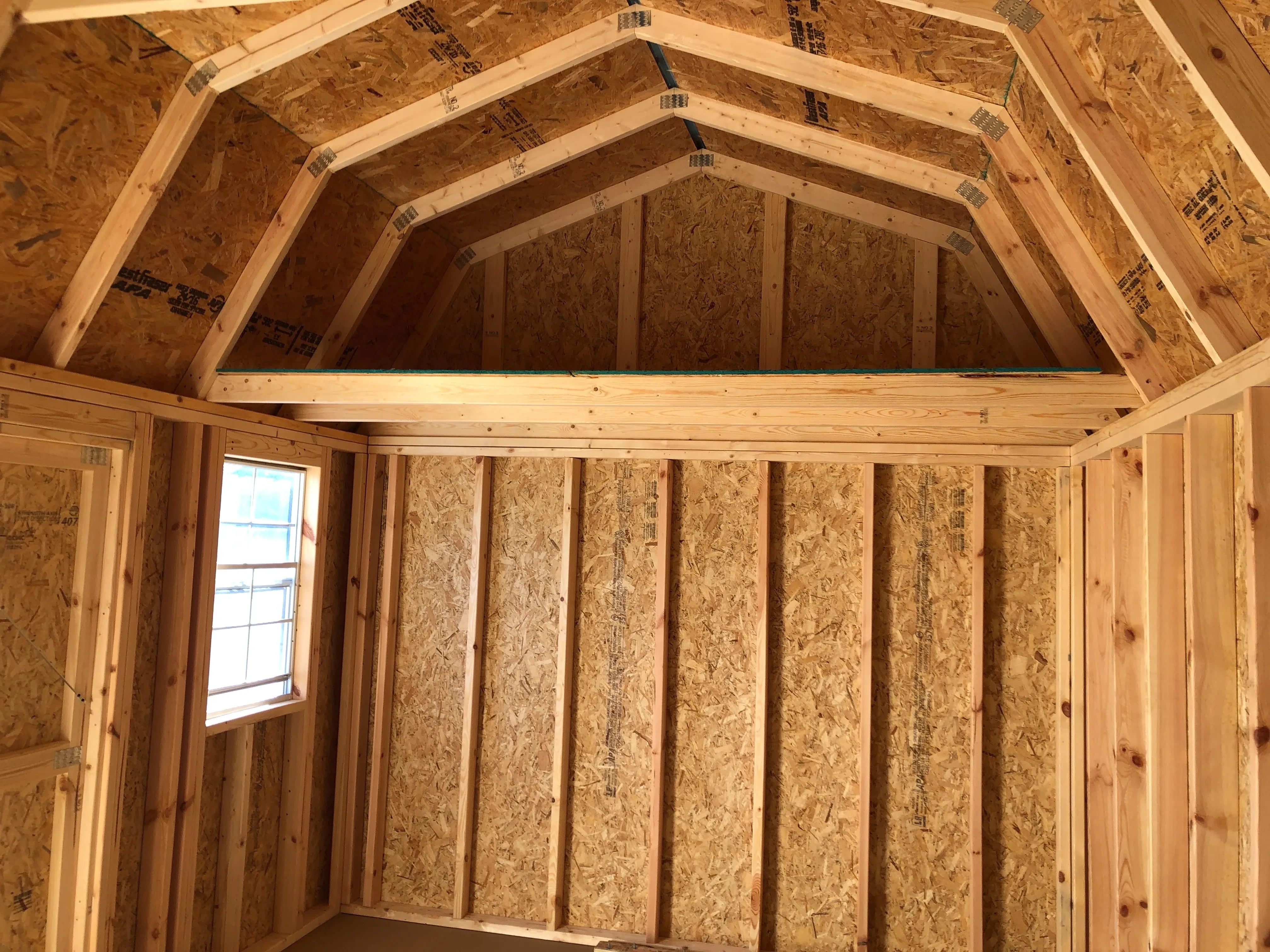 interior of 10x16 side lofted barn showing a window and loft