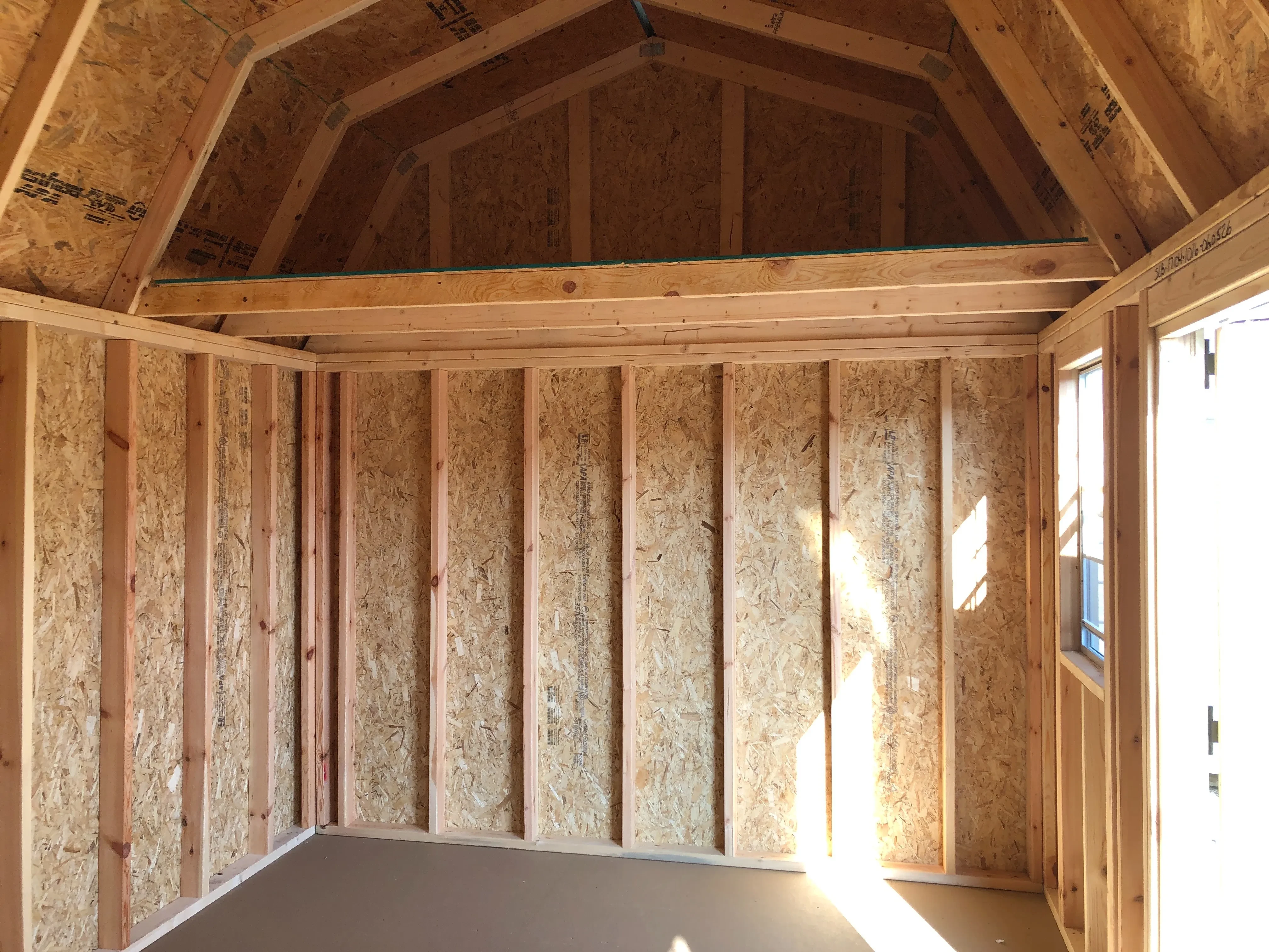 interior of 10x16 side lofted barn showing a window and loft