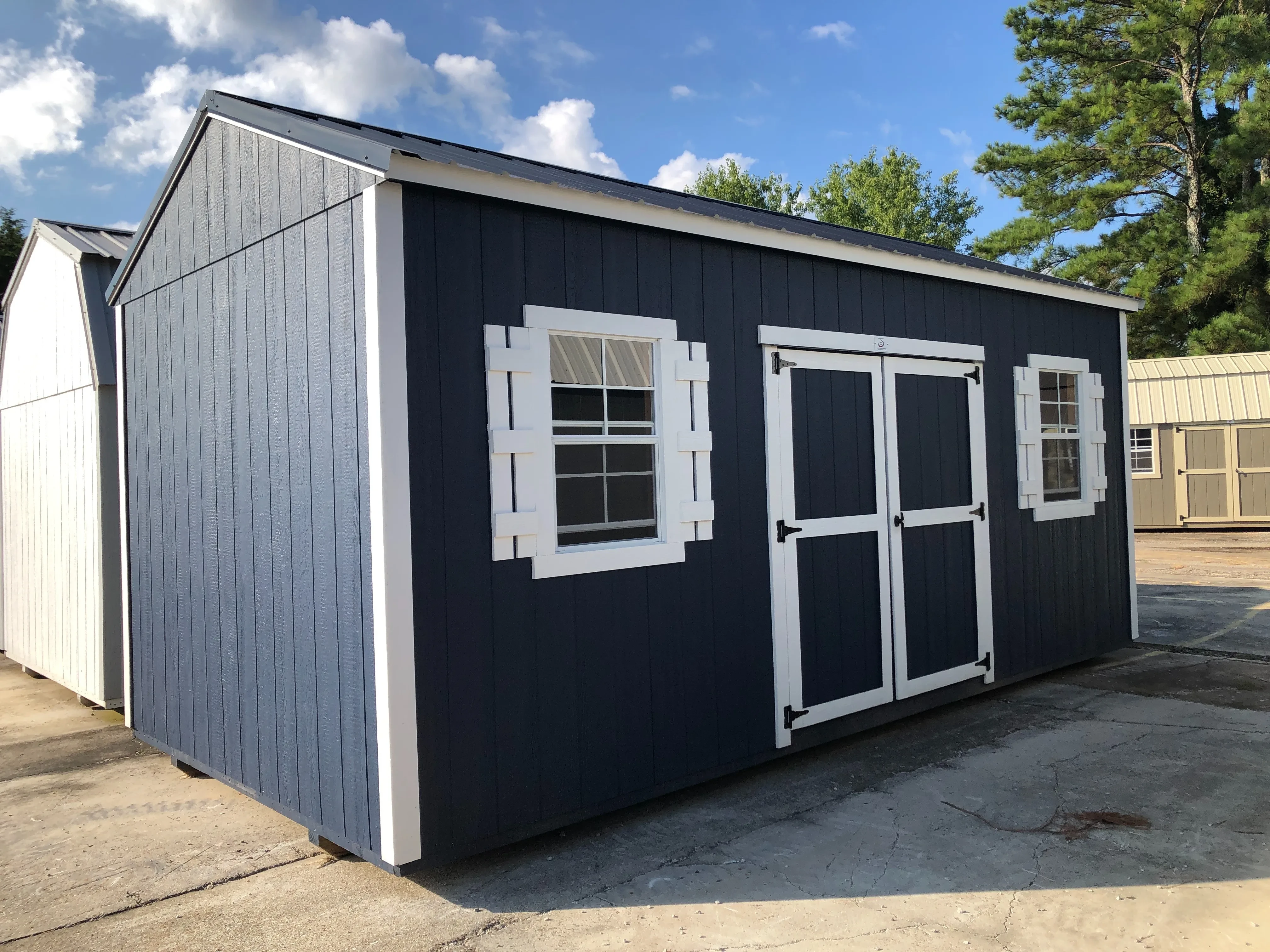 exterior of 10x20 blue and white garden shed showing double doors and windows