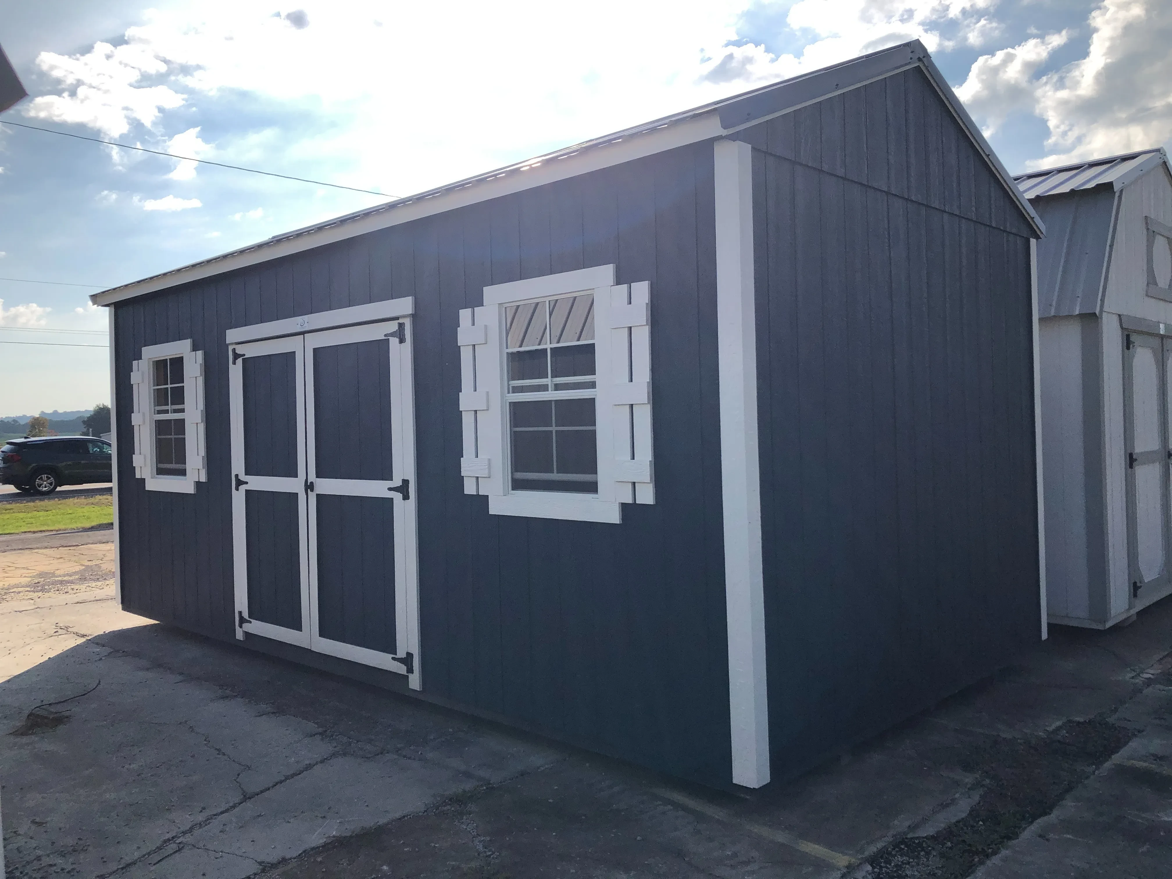 exterior of 10x20 blue and white garden shed showing double doors and windows