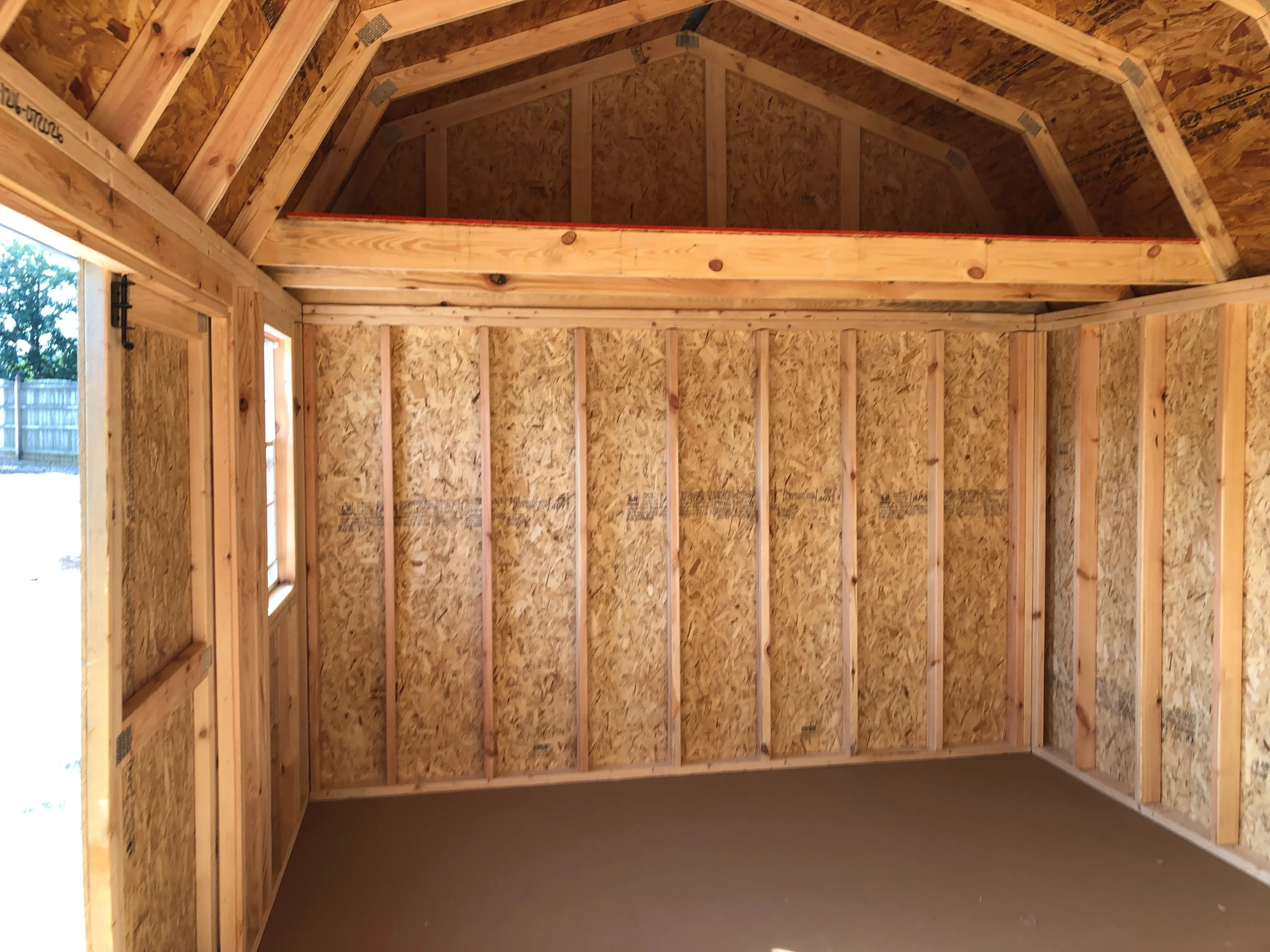 interior of 12x16 side lofted barn showing loft, floor, window and doorway