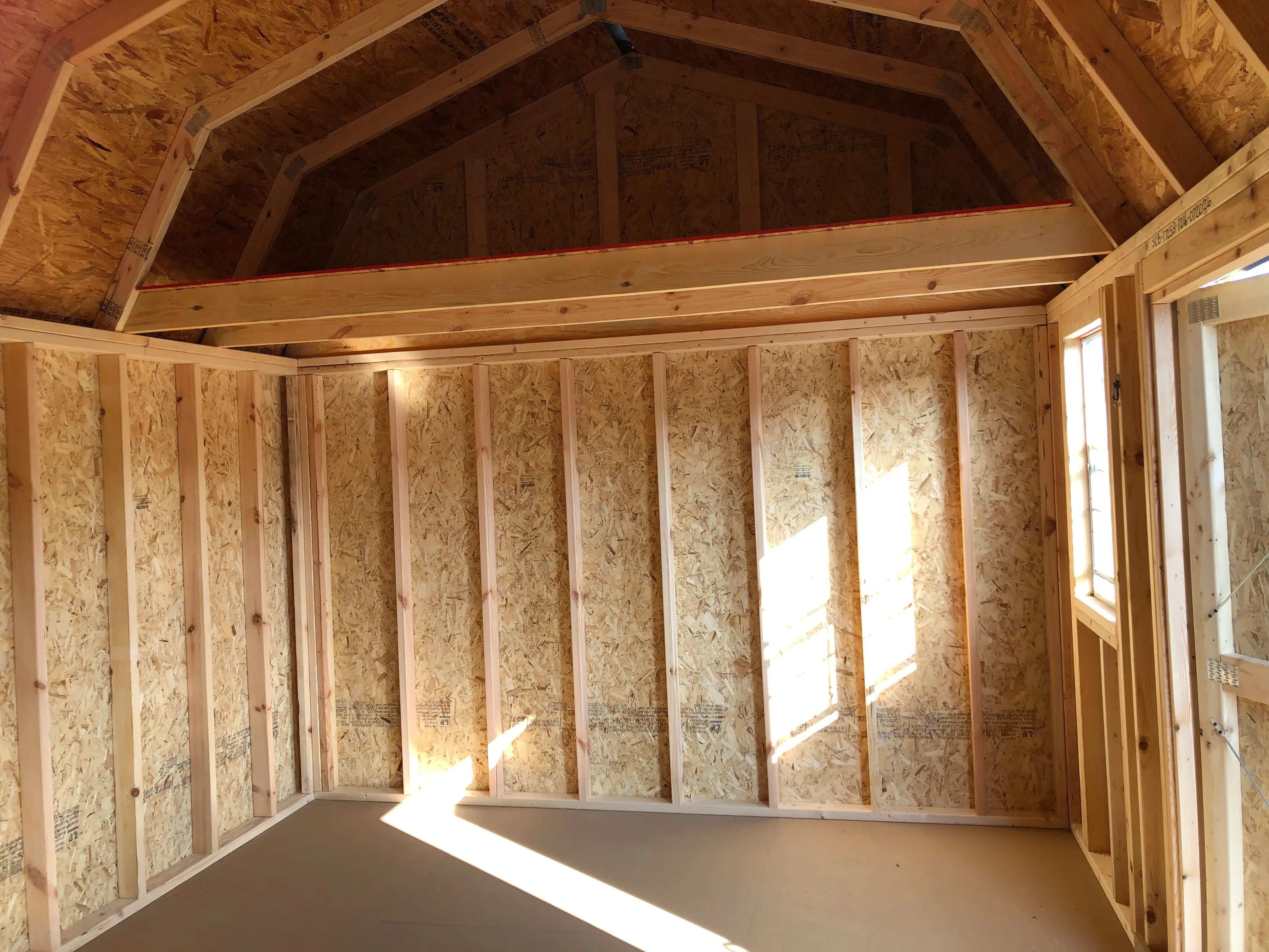 interior of 12x16 side lofted barn showing loft, floor, window and doorway