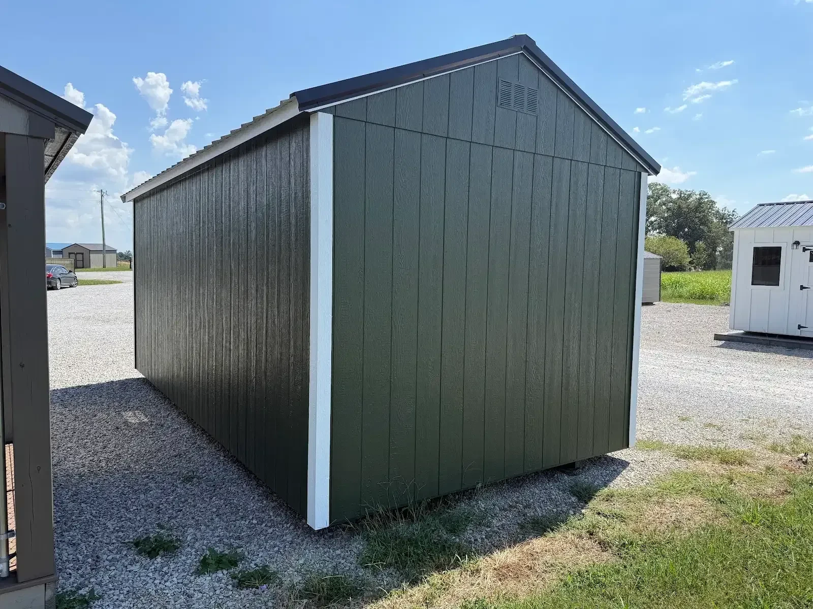 The back and end of a dark green garden shed