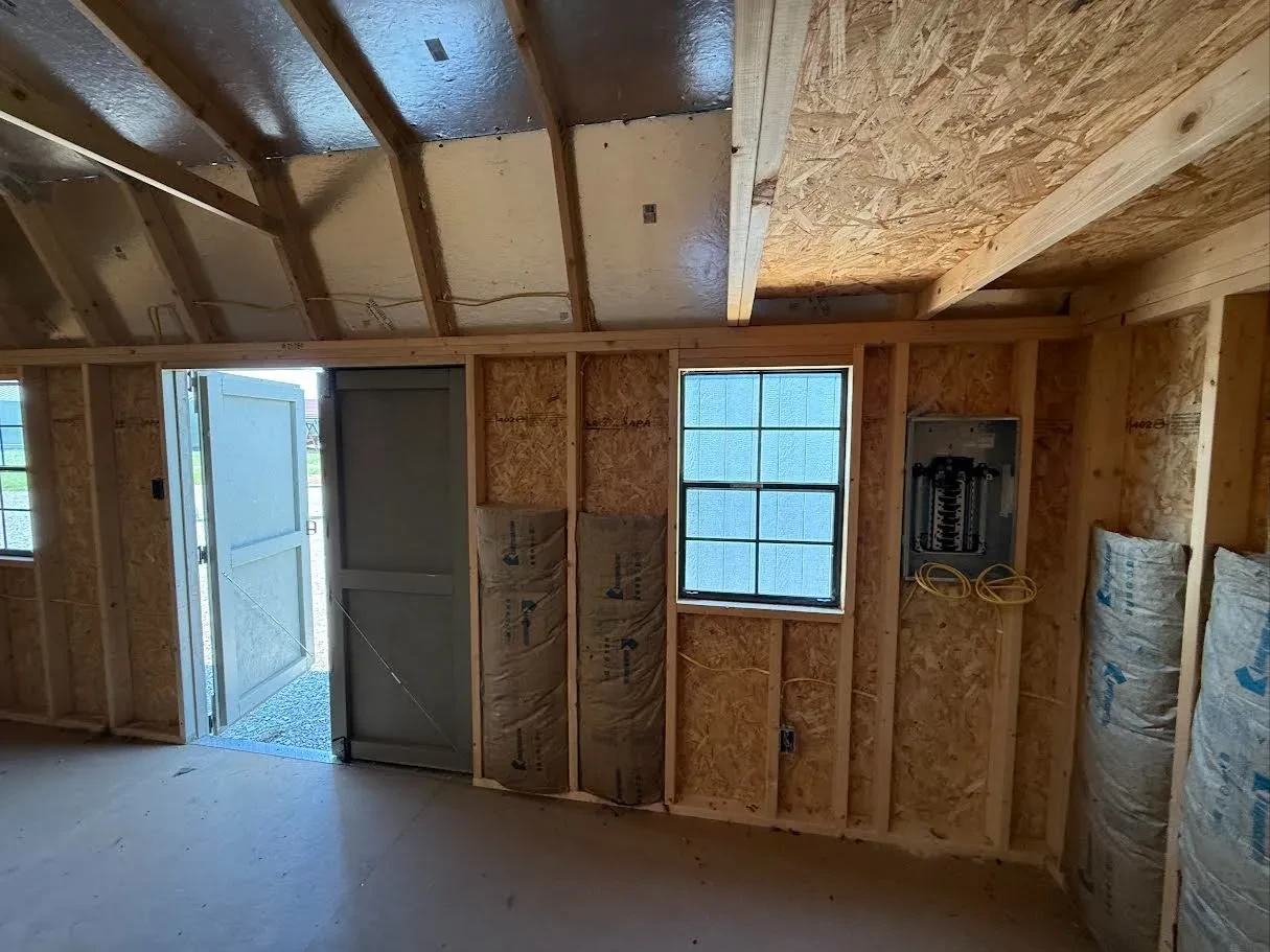 Inside of a 10x20 side garden shed with lofts in both ends and some batt insulation and wiring