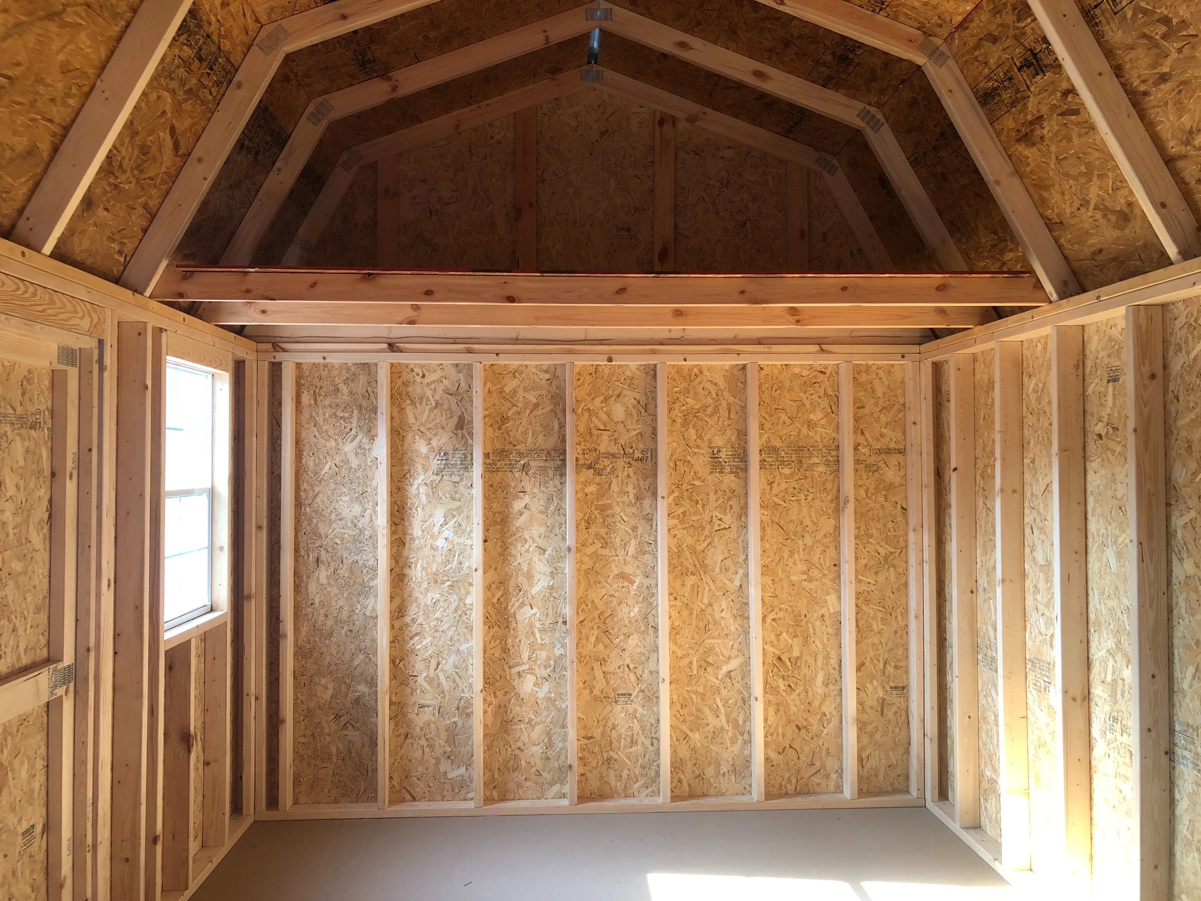interior of 10x16 side lofted barn showing a window, loft and floor