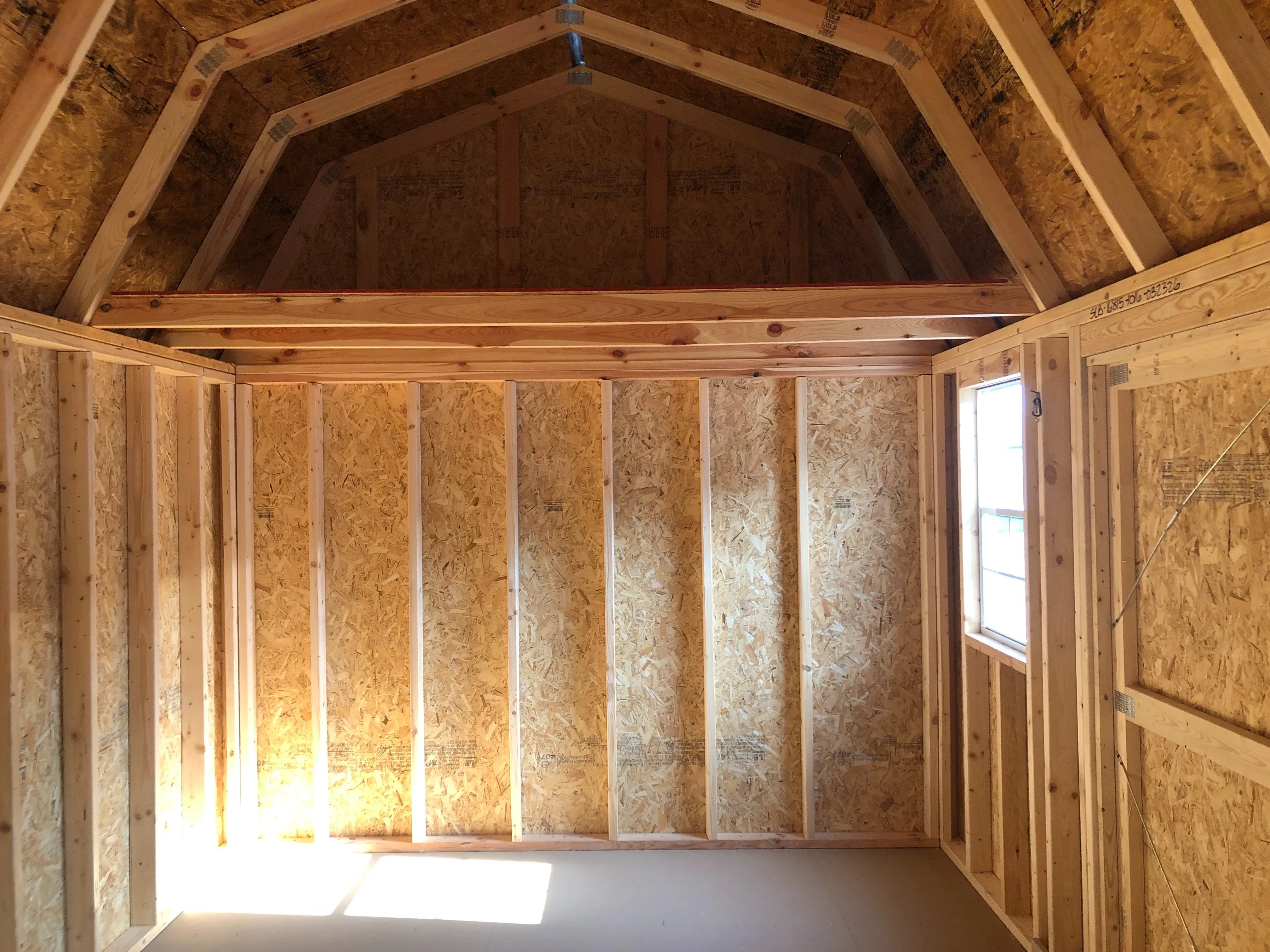 interior of 10x16 side lofted barn showing a window, loft and floor