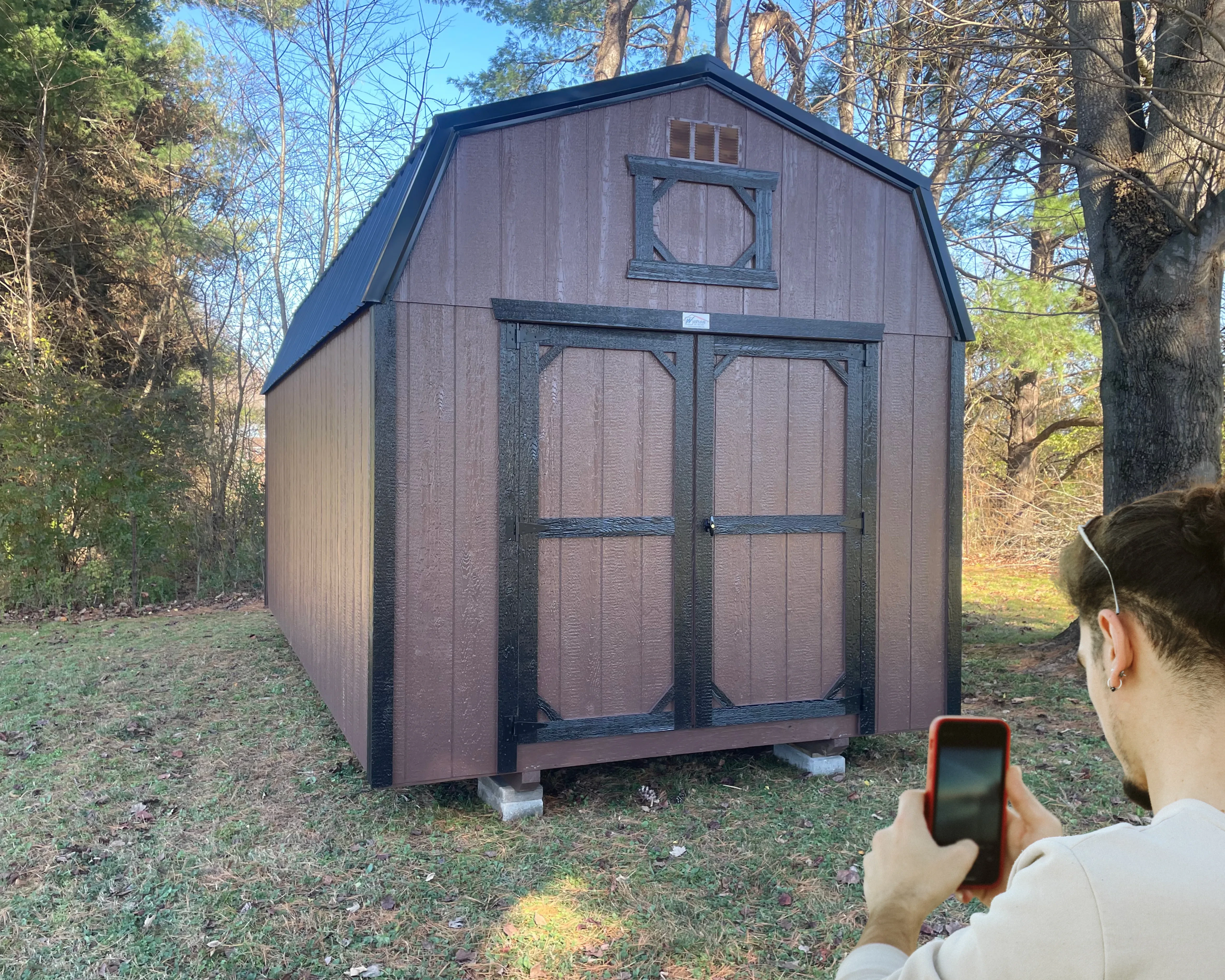 Man taking a picture of a shed to send for a move quote