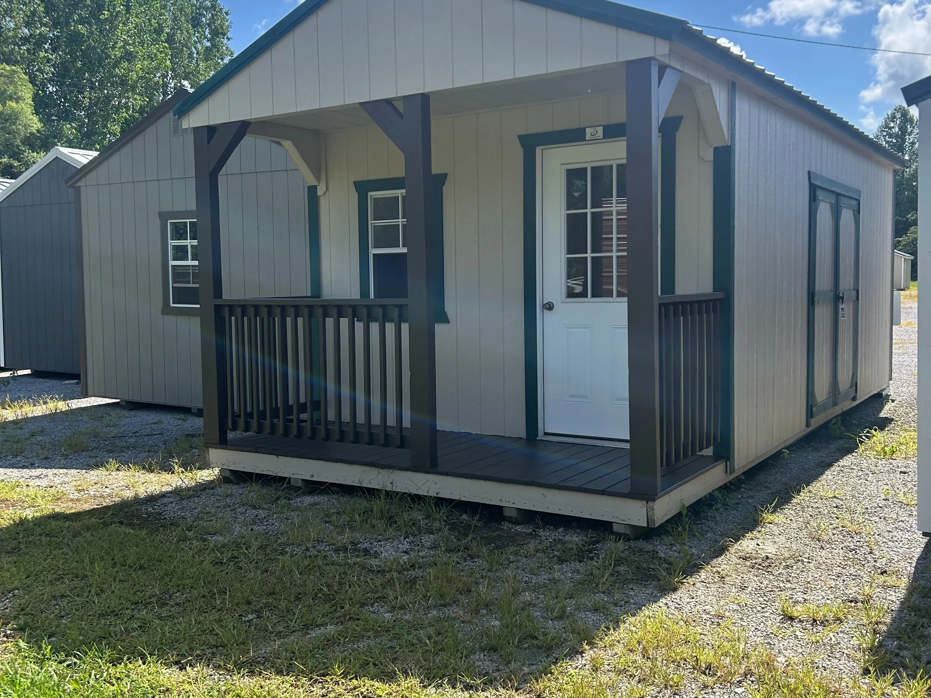 The front right view of 12x24 classic wood cabin; showing porch and double doors