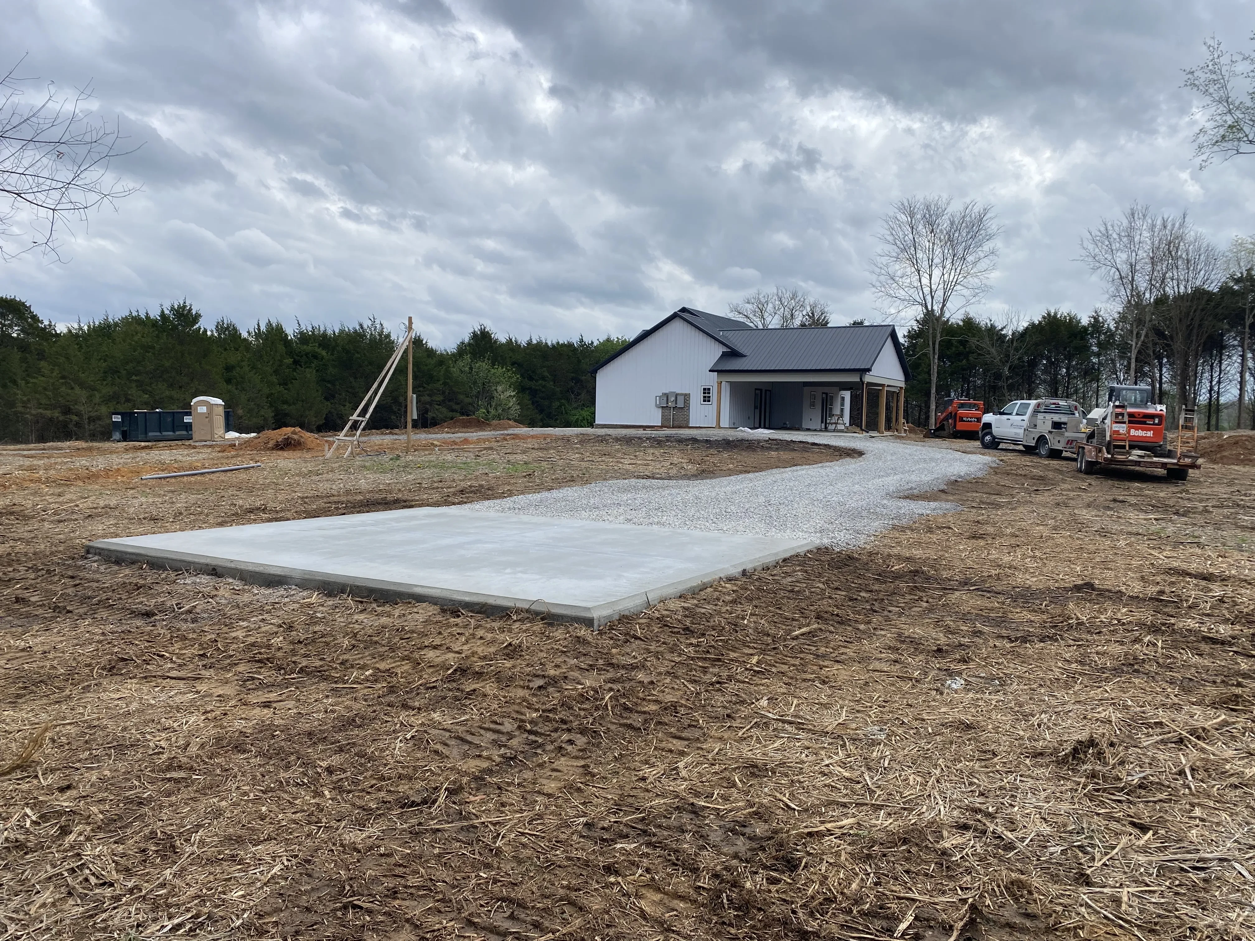 Newly finished concrete slab and driveway with equipment on a trailer