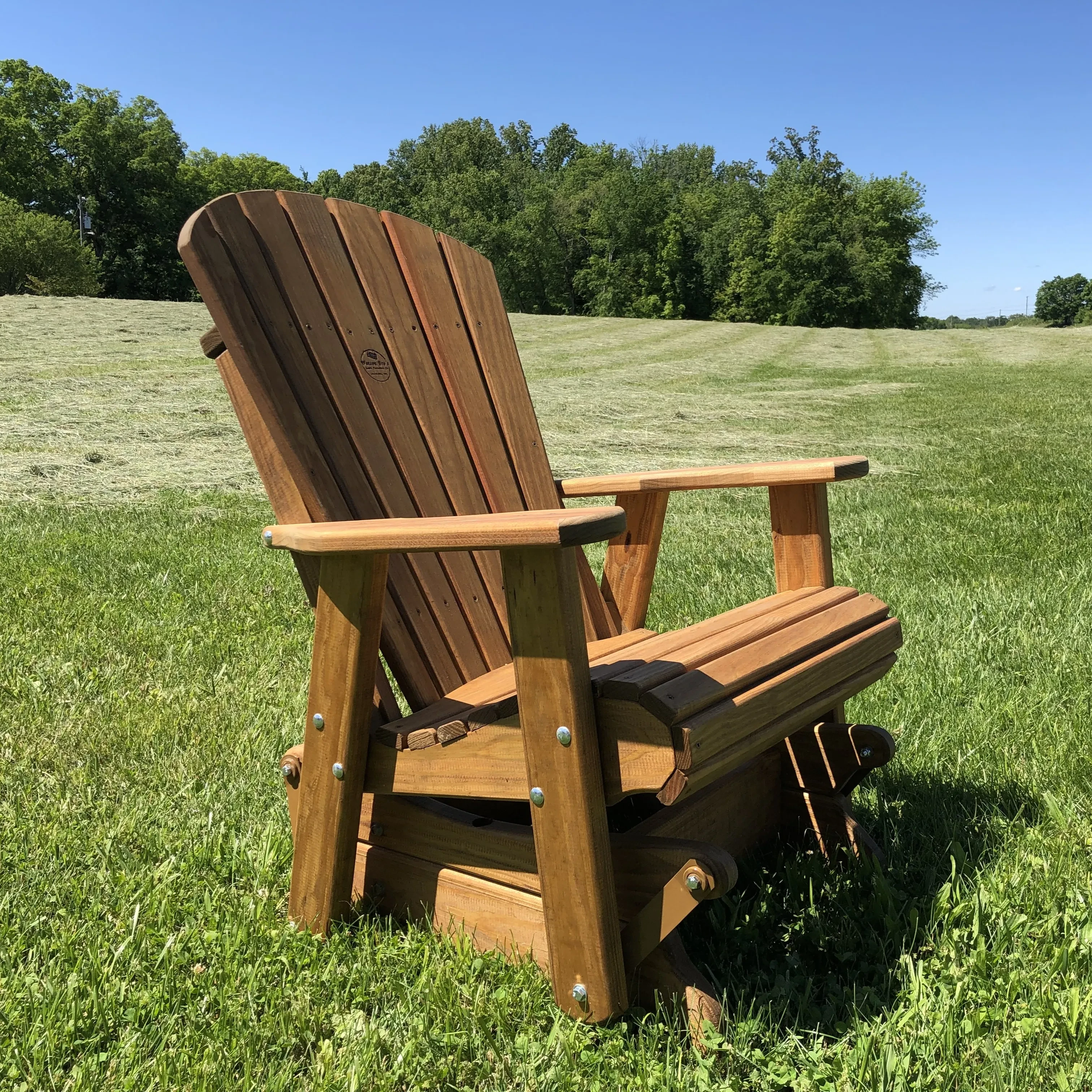 a piece of wood outdoor patio furniture sitting in a grass field