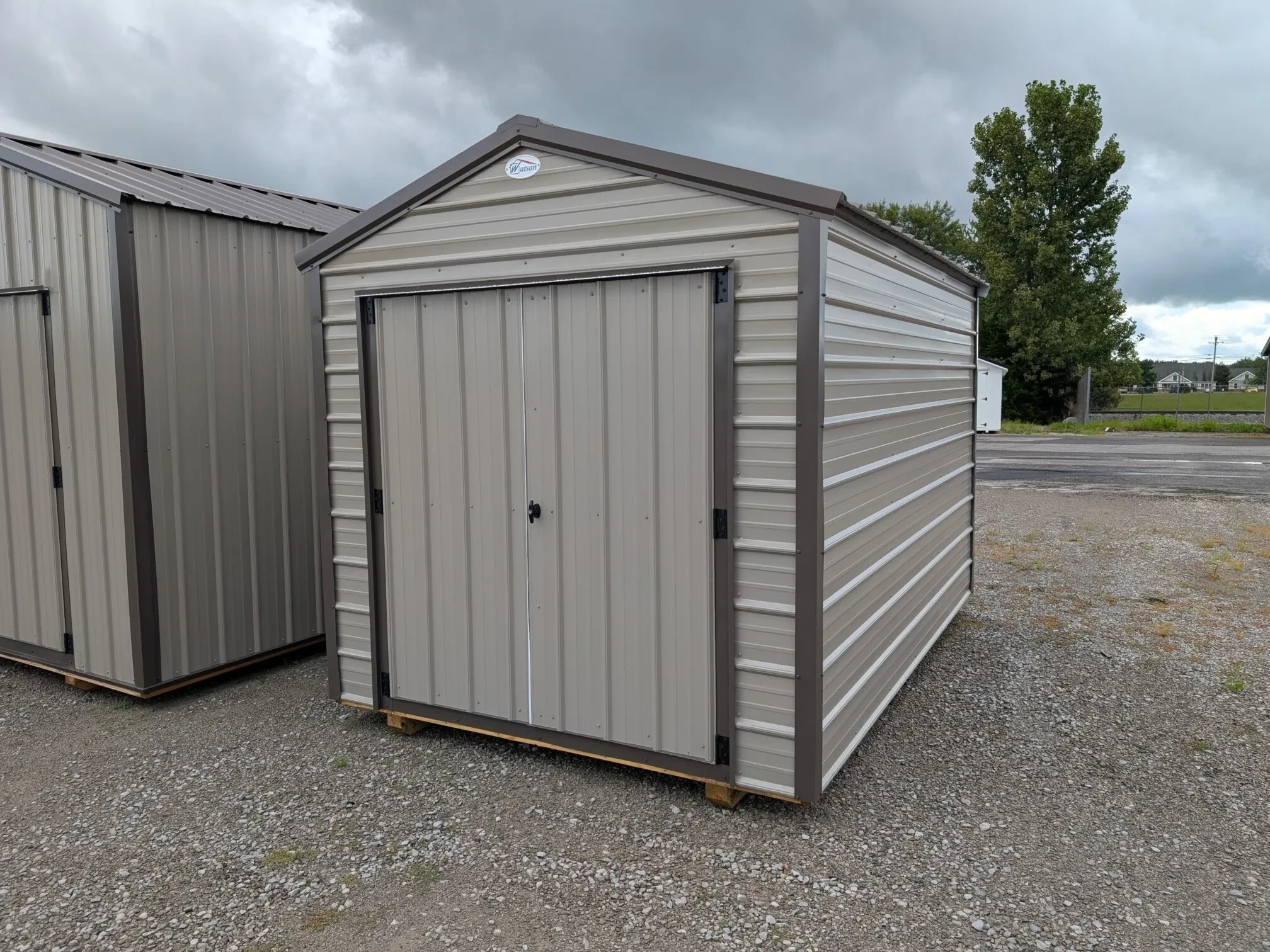 A Clay colored metal shed with double doors